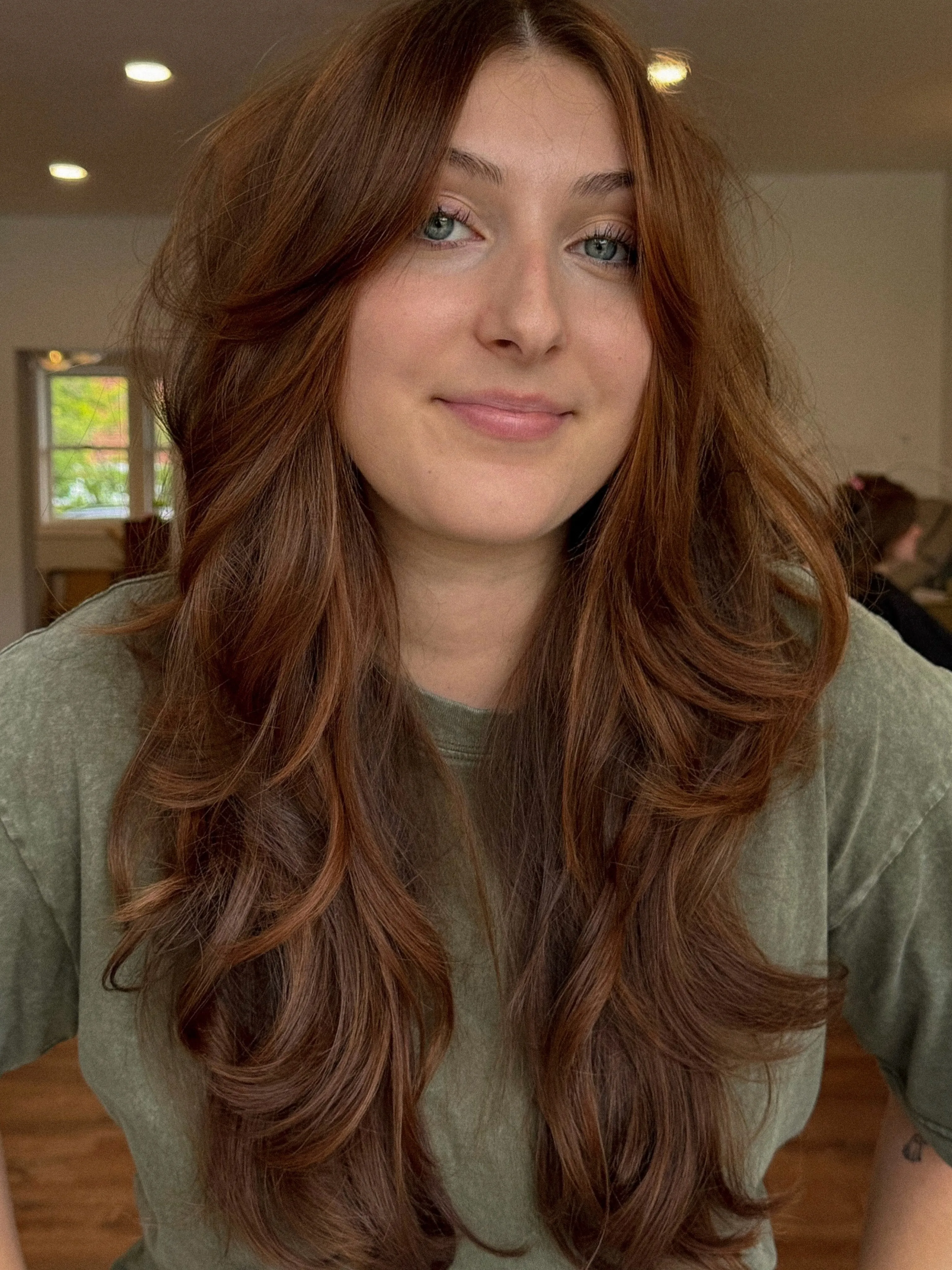 Long chestnut blowout with curtain bangs and face-framing layers