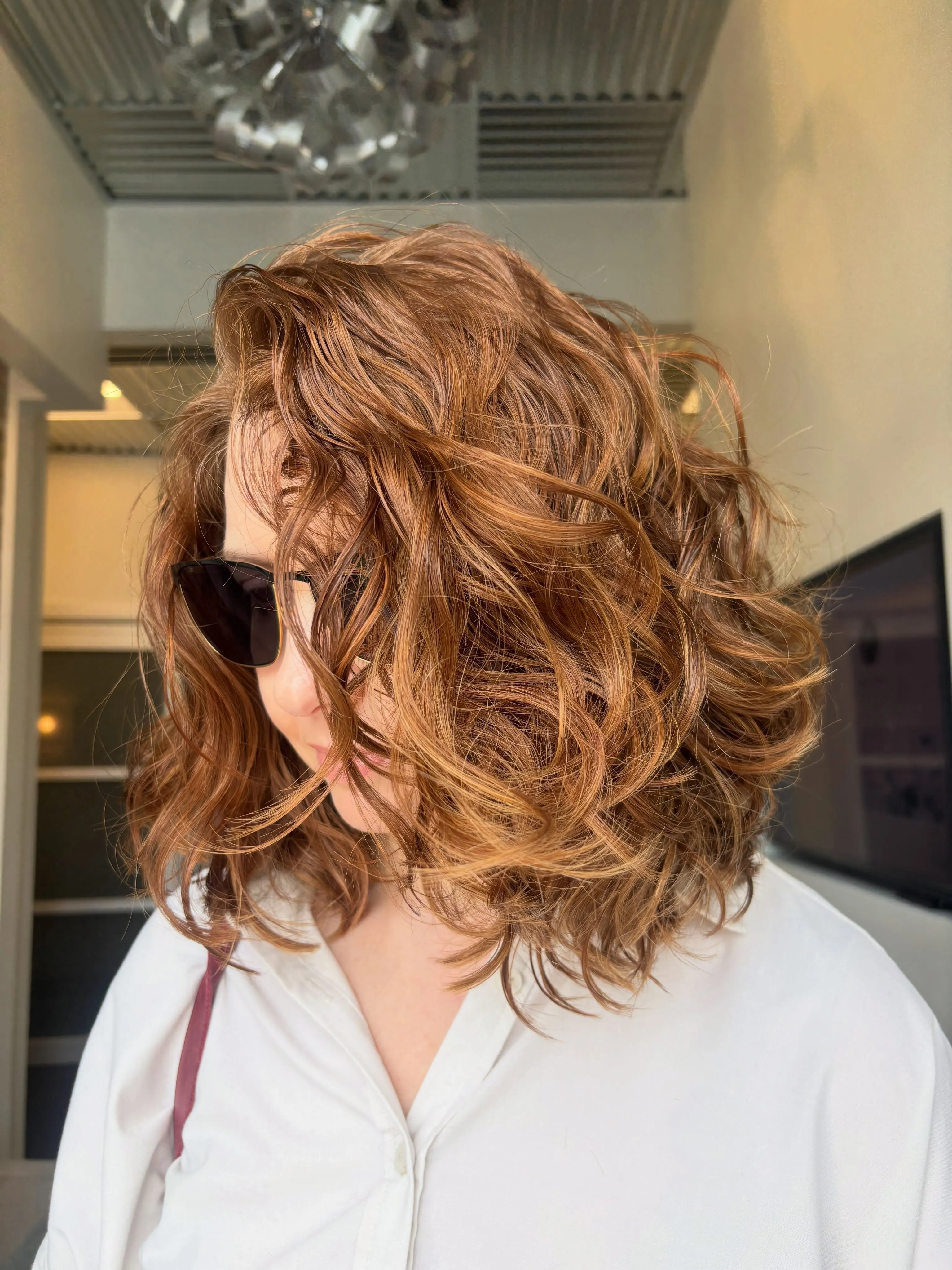 Tousled shoulder-length wavy bob with side-swept volume