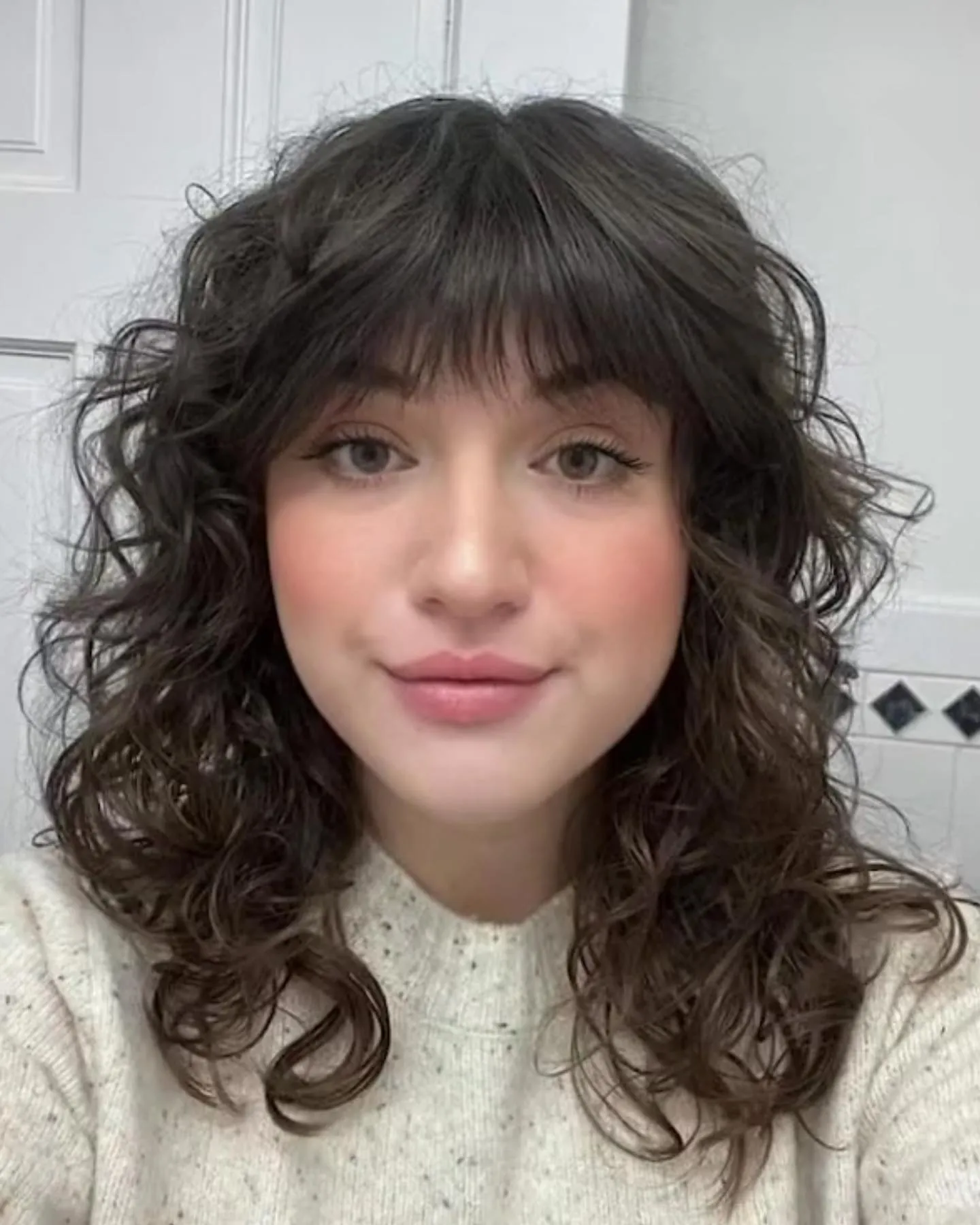 Rounded dark shag with soft fringe and curled ends