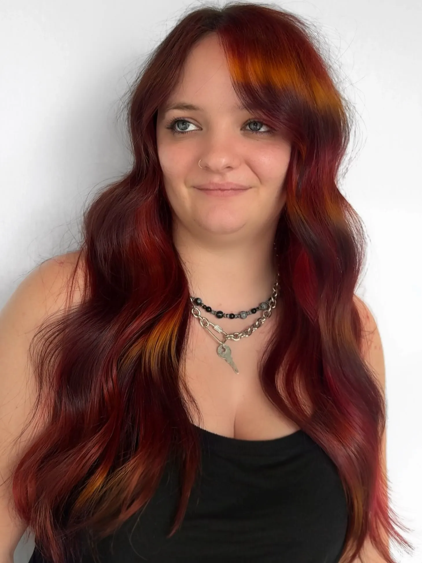 Long deep red waves with soft curtain bangs