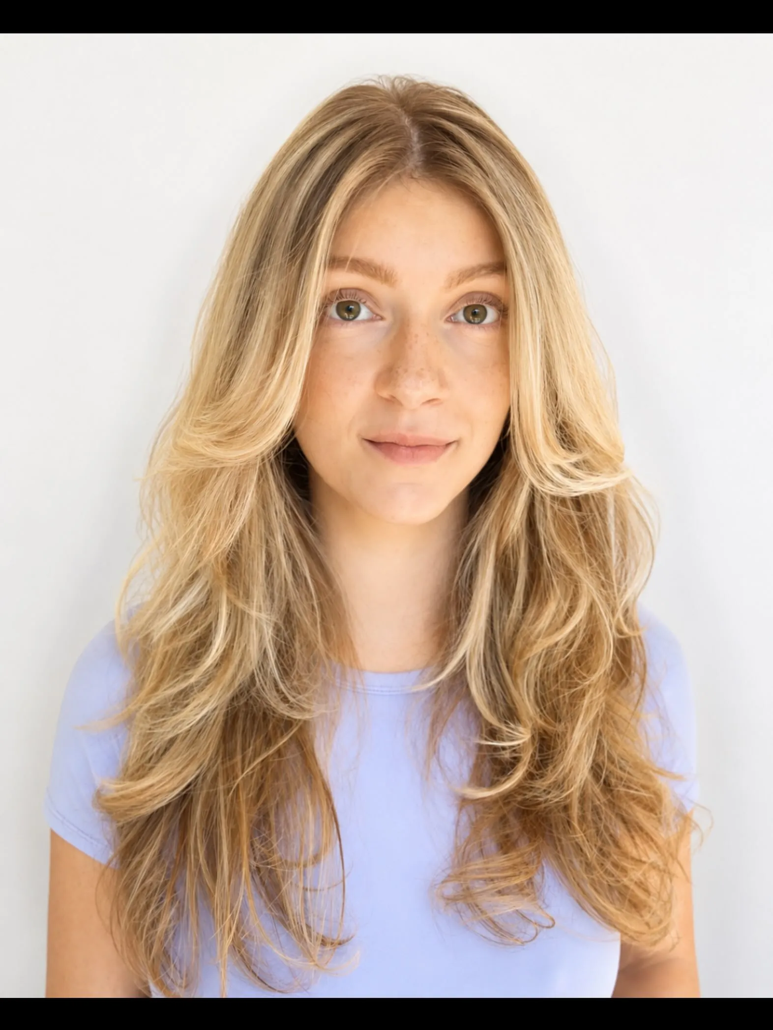 Long blonde haircut with feathered face-framing layers