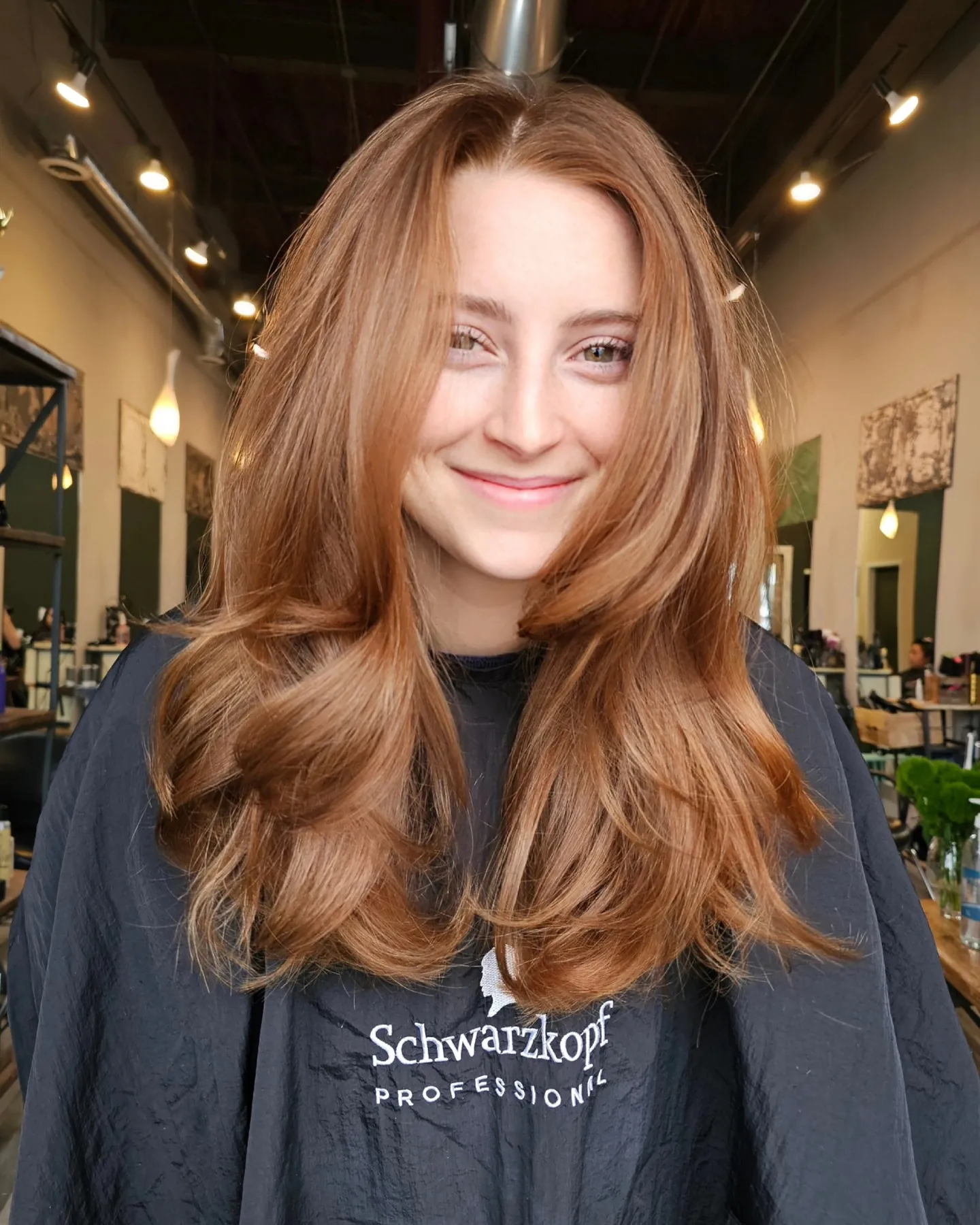 Center-parted long auburn layers with curved face framing