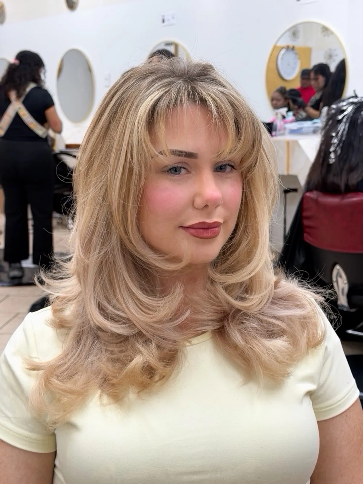 Feathered blonde medium layers with wispy bangs