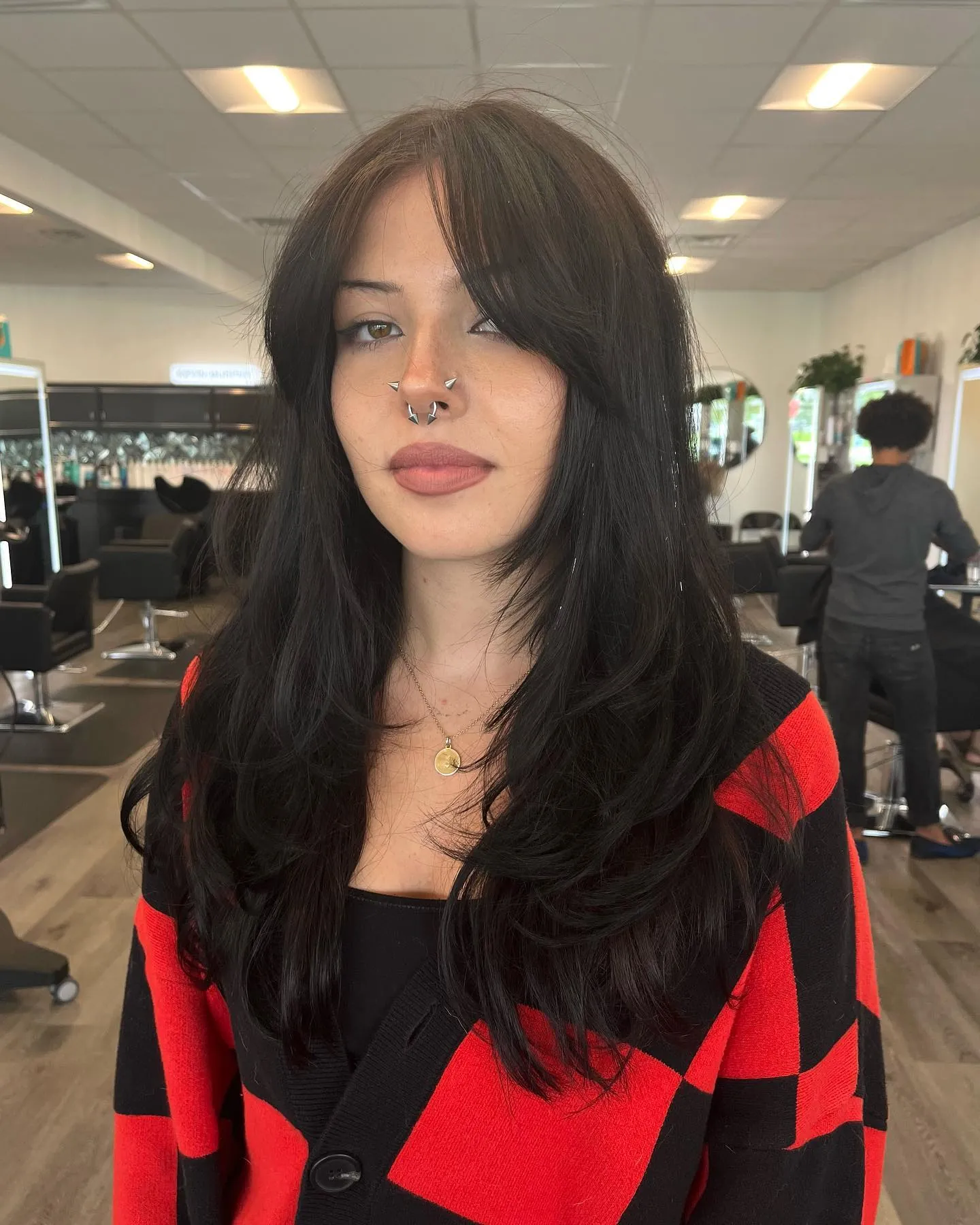 Long dark layered haircut with center-parted face framing