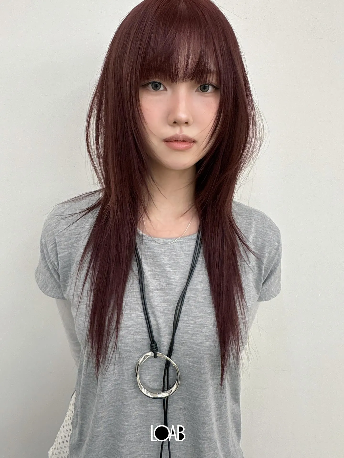 Sleek burgundy long layers with straight full bangs