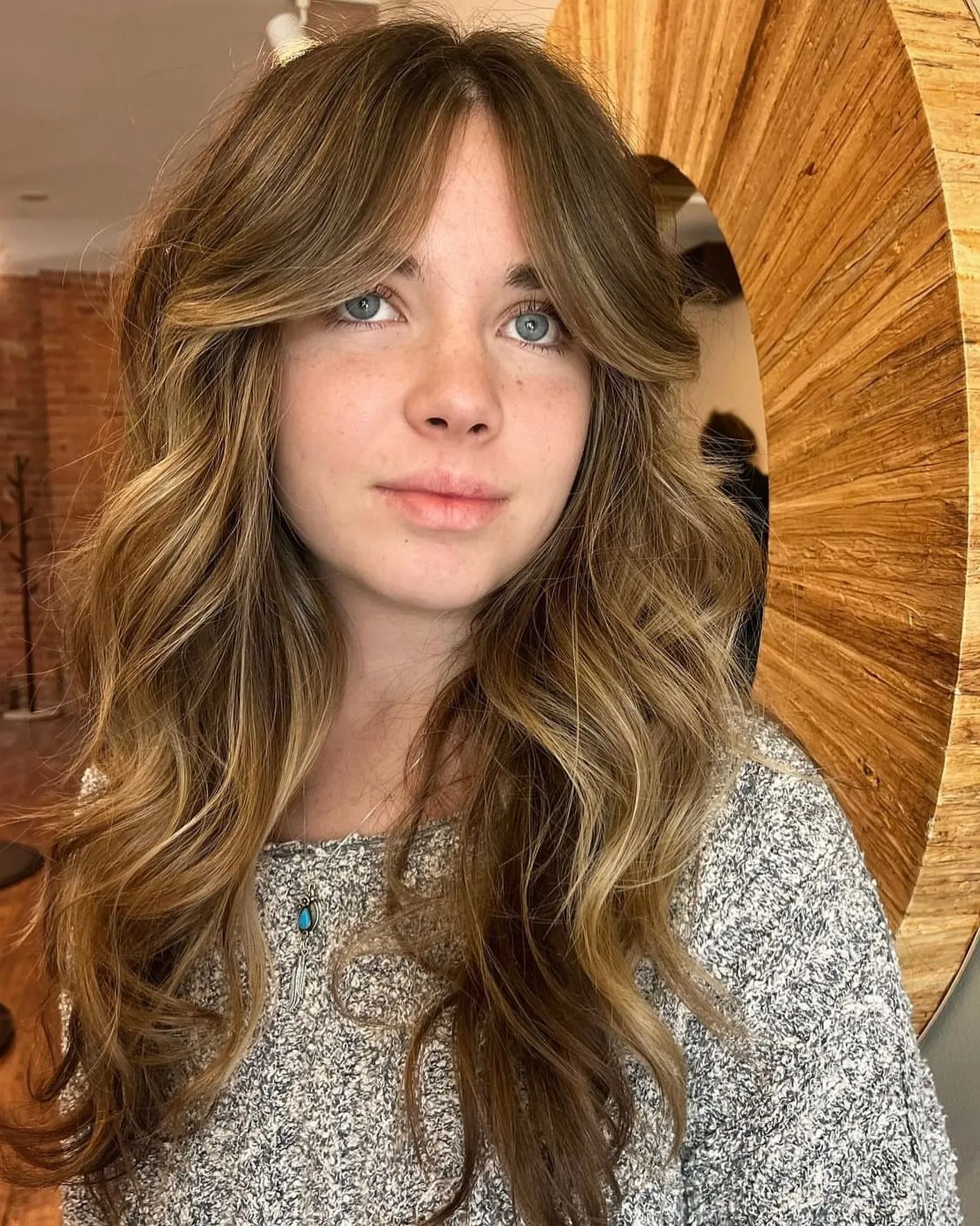 Long wavy layers with curtain bangs and lifted face framing