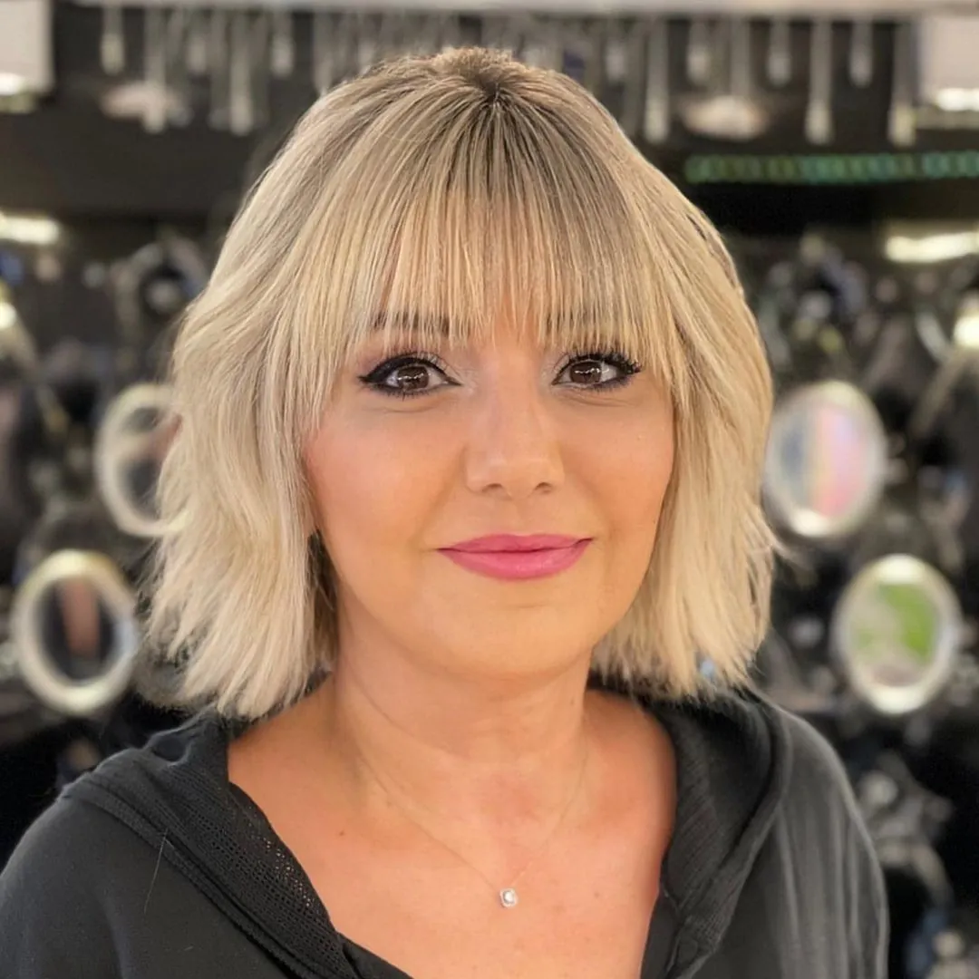 Blonde bob with full bangs and feathered flipped ends