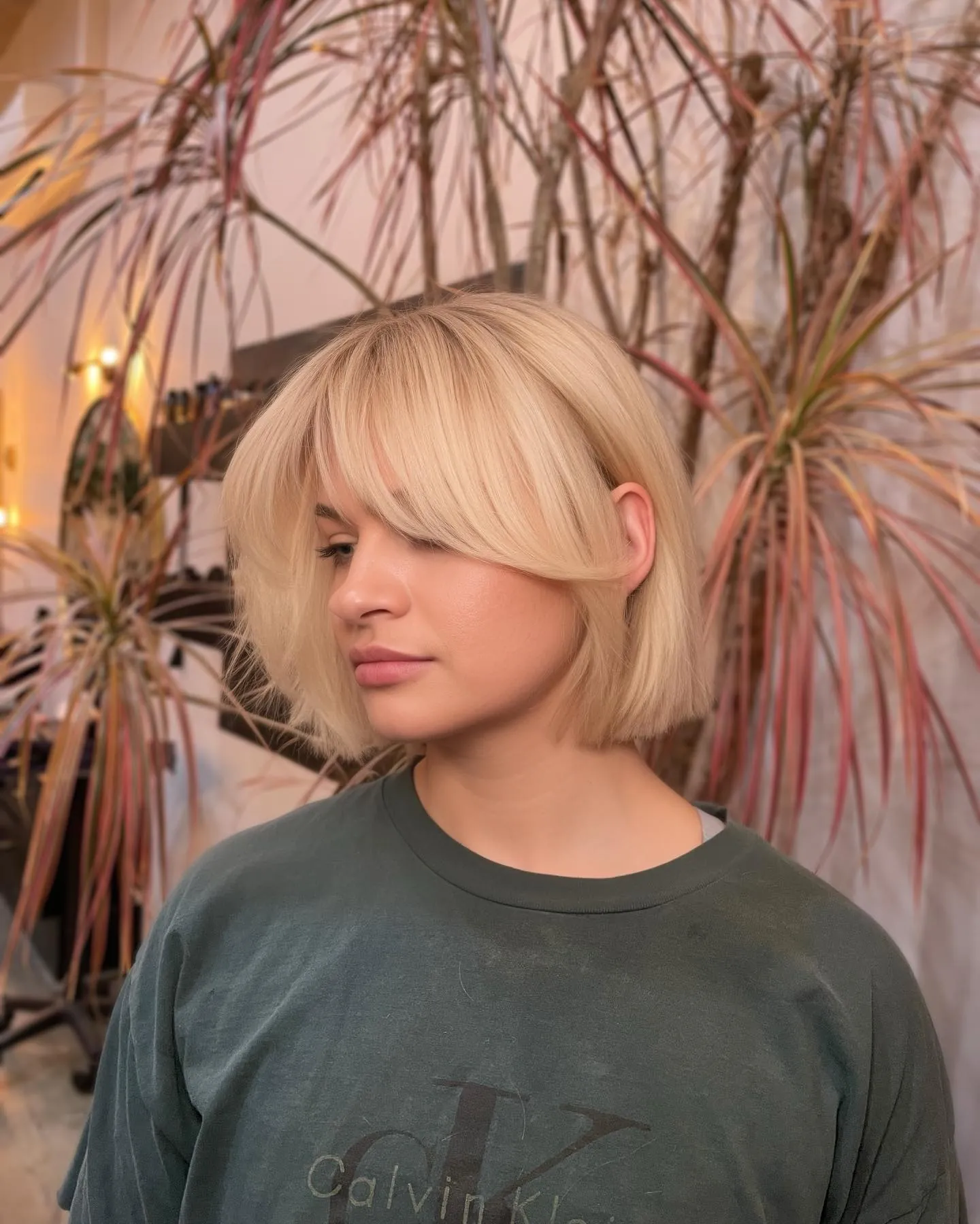 Rounded blonde bob with full fringe and curved ends