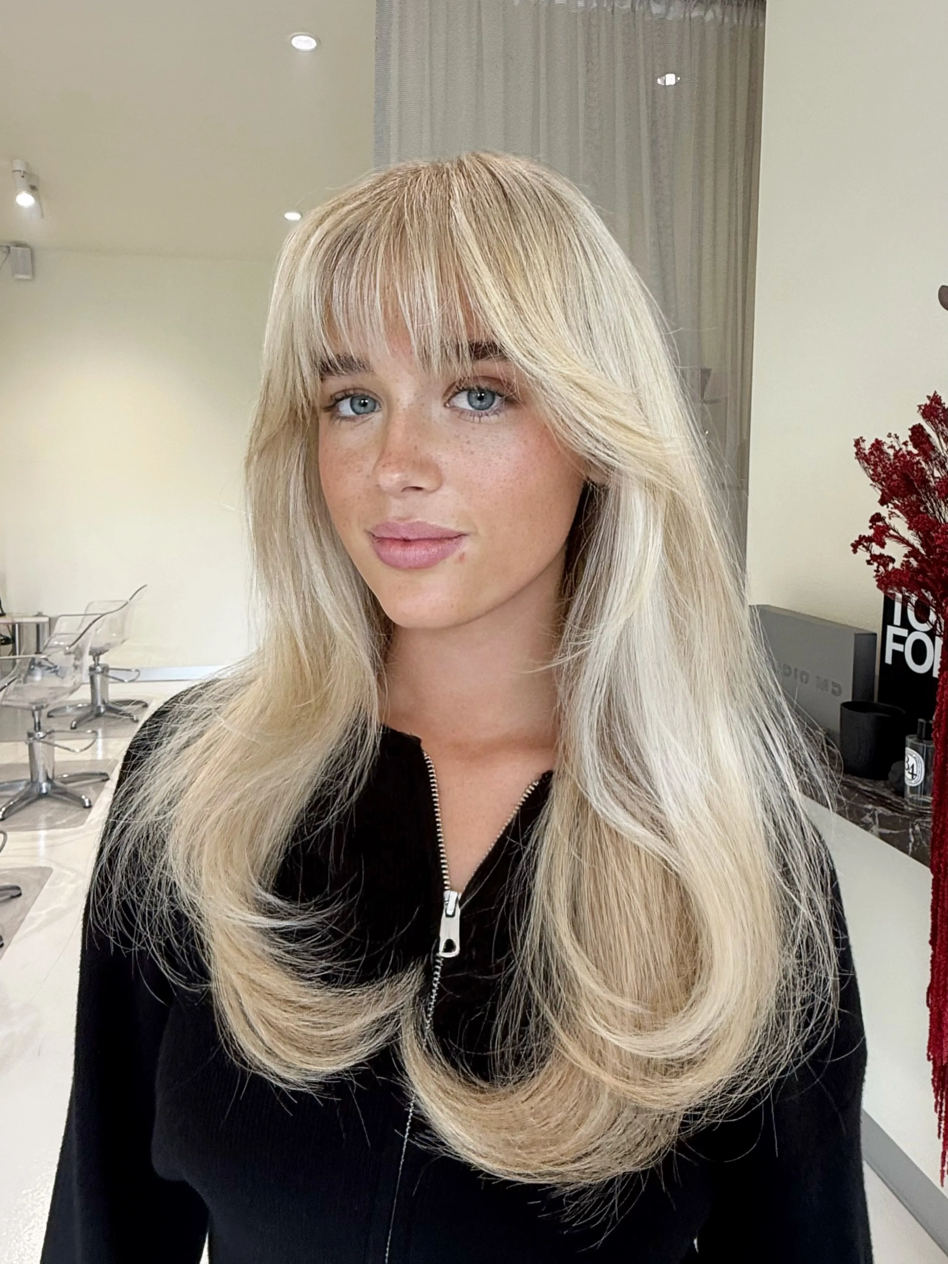 Long blonde layers with full wispy bangs
