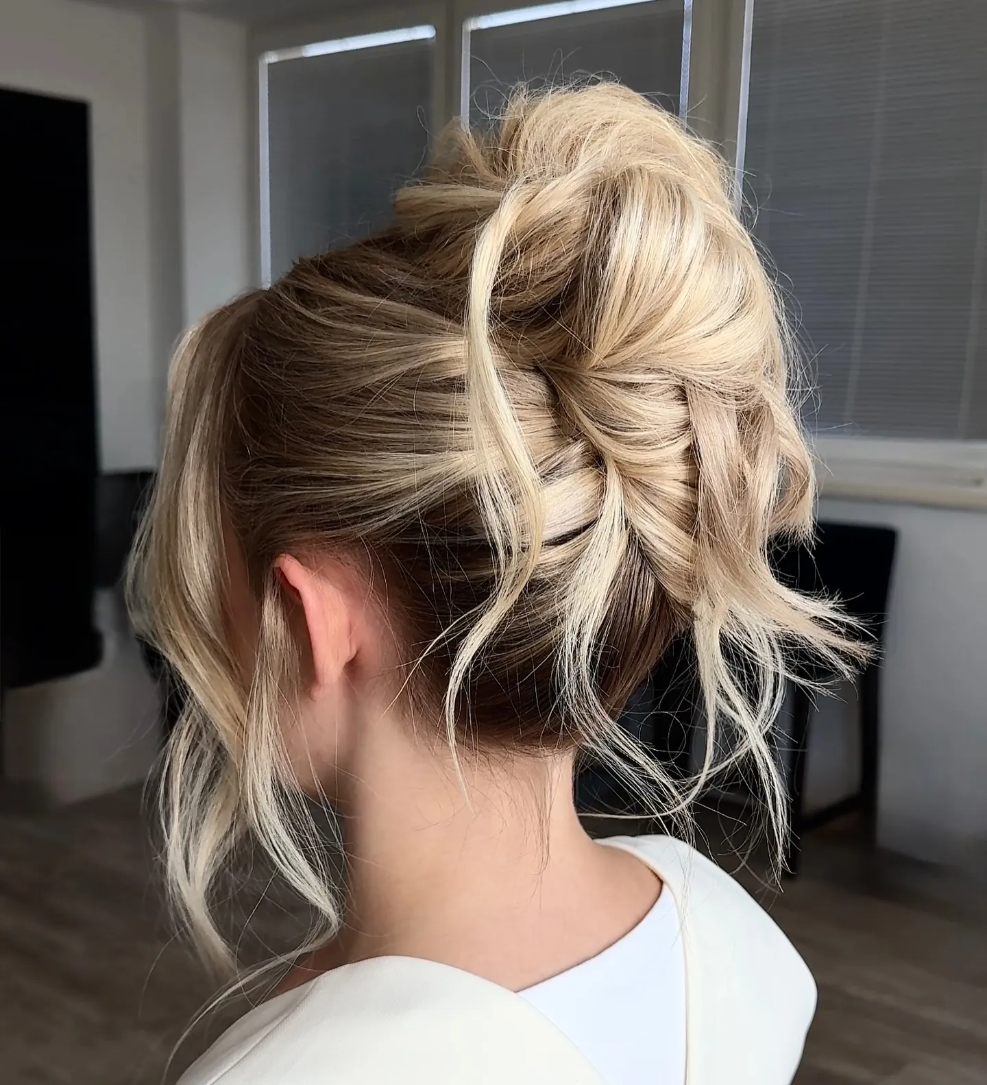 Loose blonde French twist with wispy face framing pieces