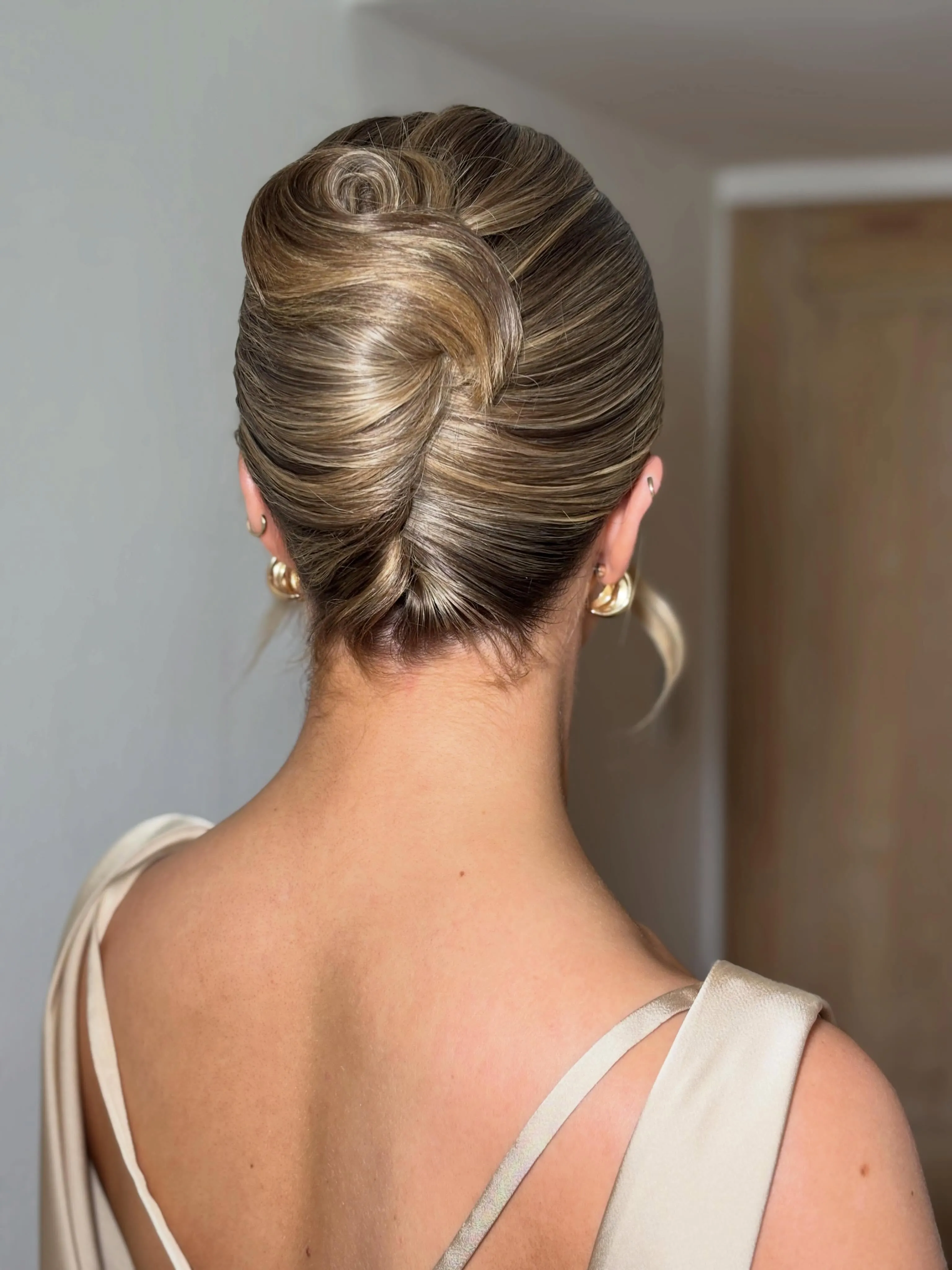 Tucked brunette French twist with sleek sides