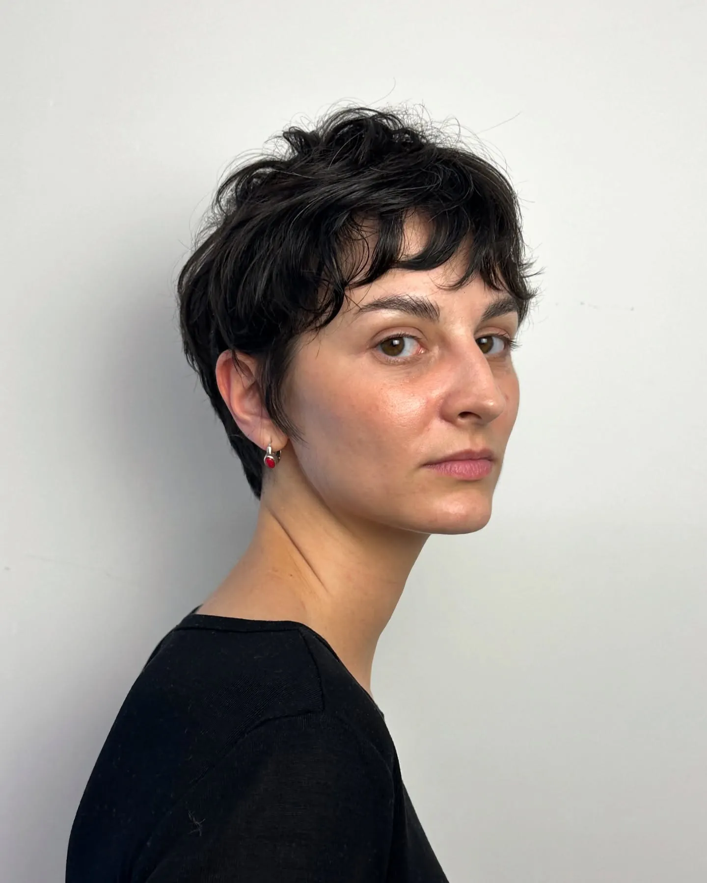 Dark tousled pixie with soft side fringe and textured crown