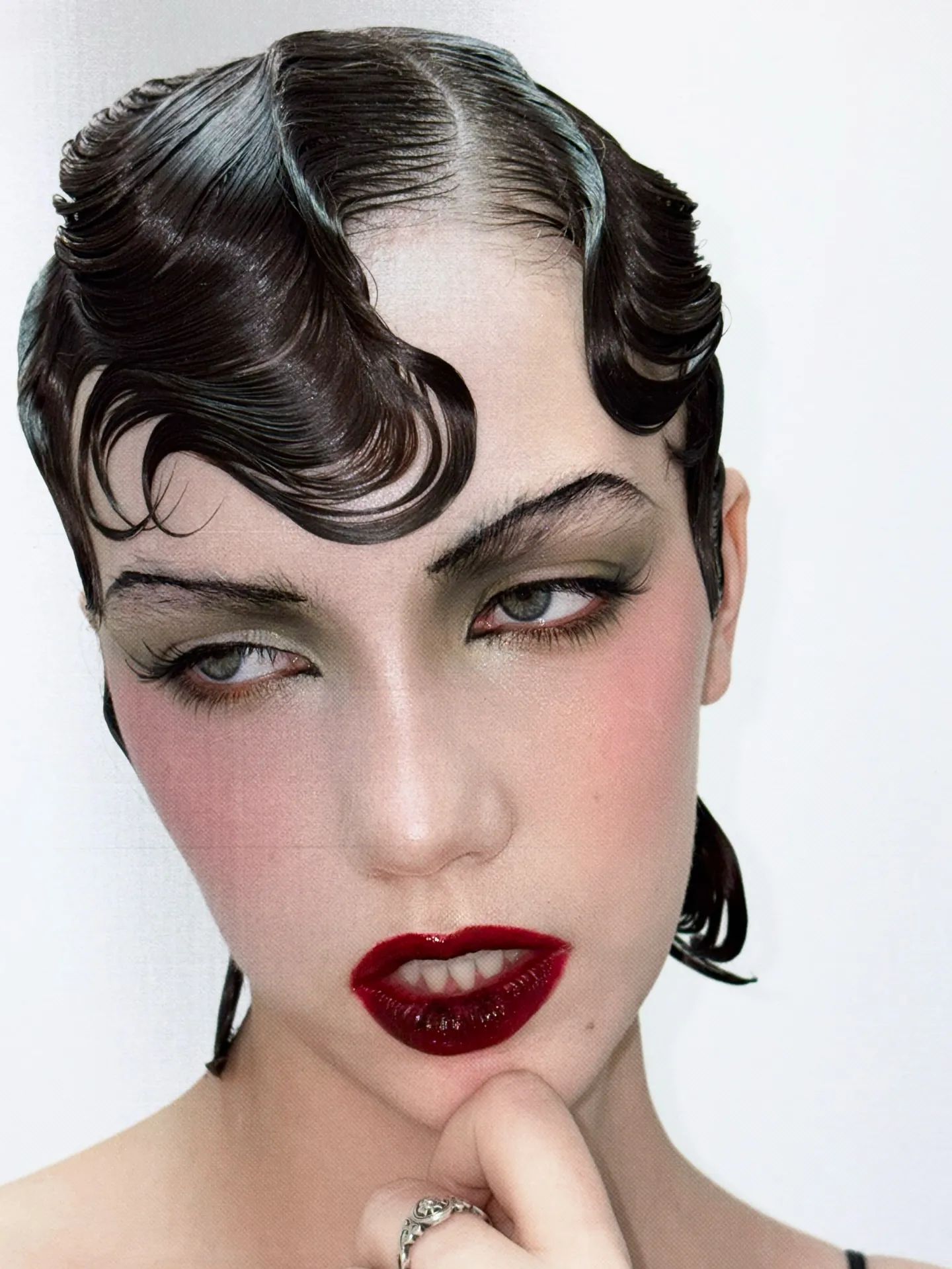 Short black sculpted finger waves with a glossy finish