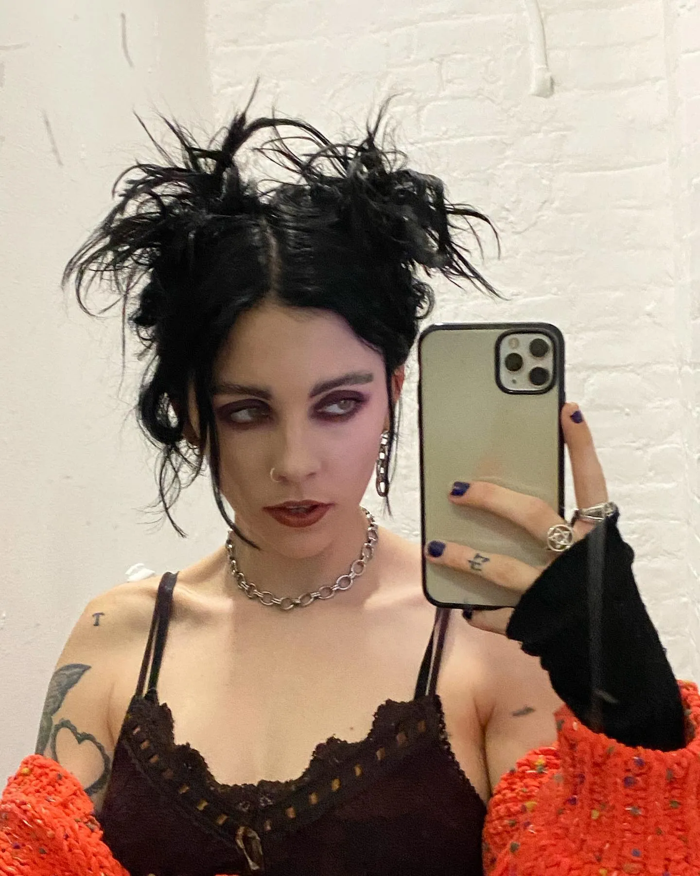 Messy black twin buns with loose wispy strands