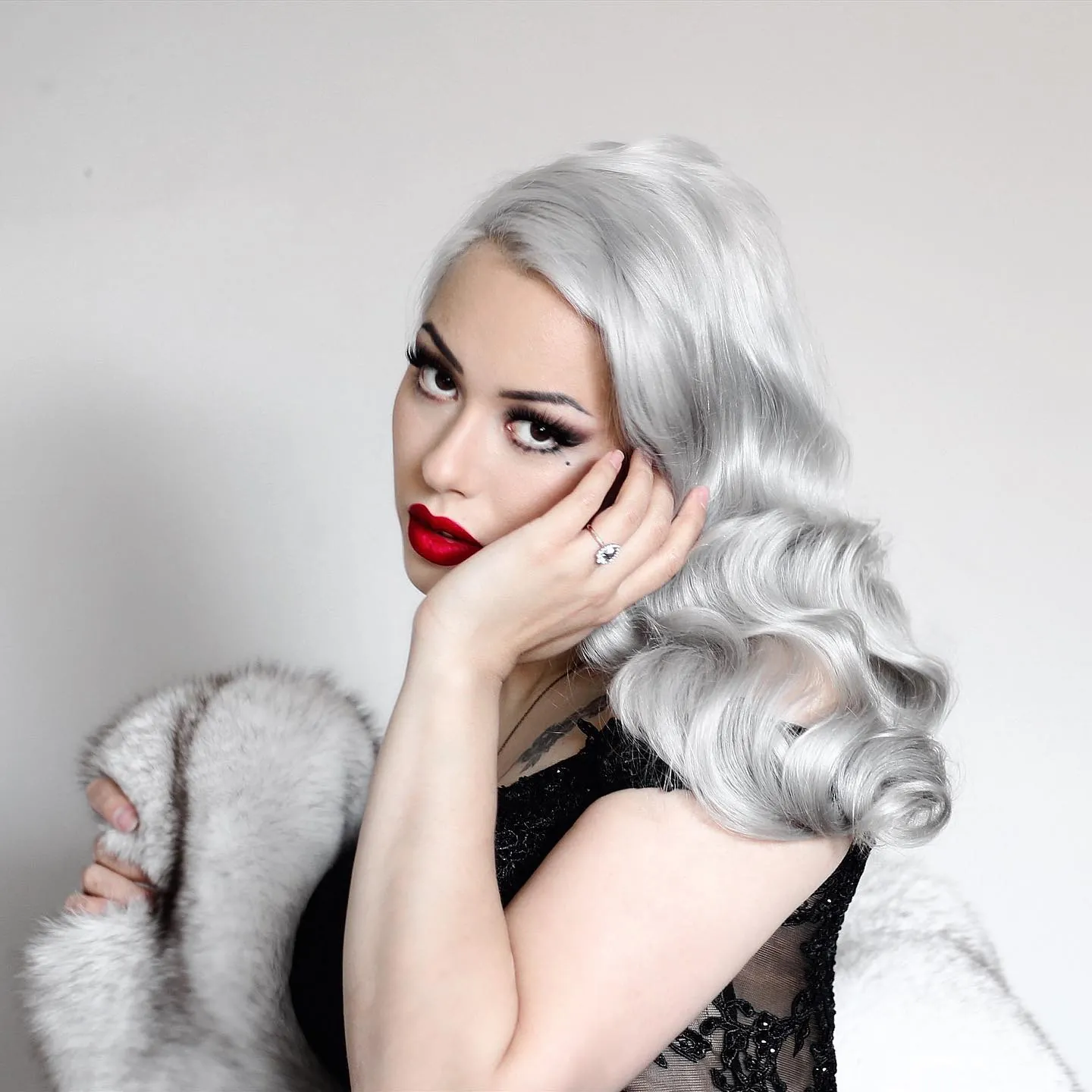 Silver shoulder-length hair styled in vintage side-parted waves
