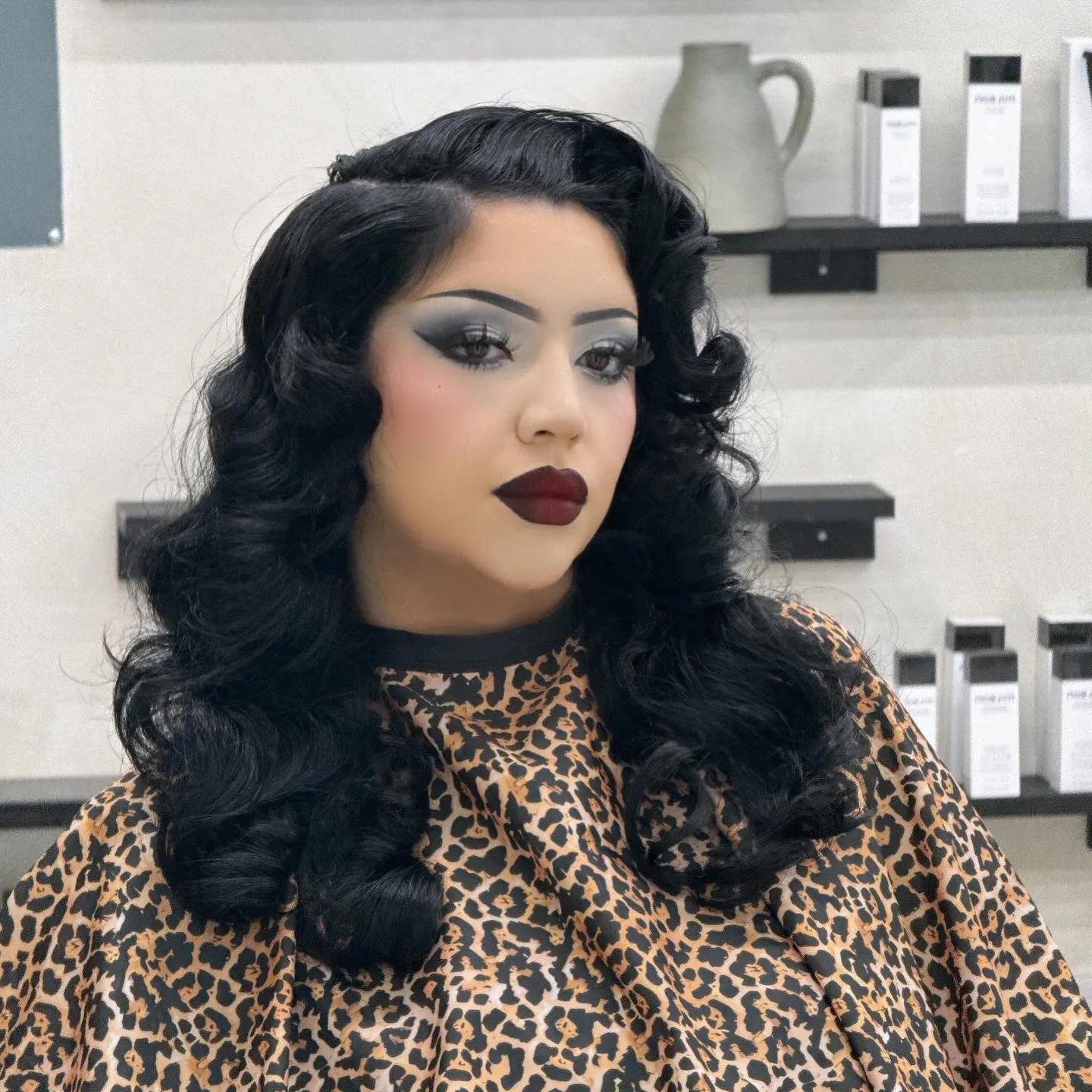 Shoulder-length black hair with brushed vintage curls and a side part