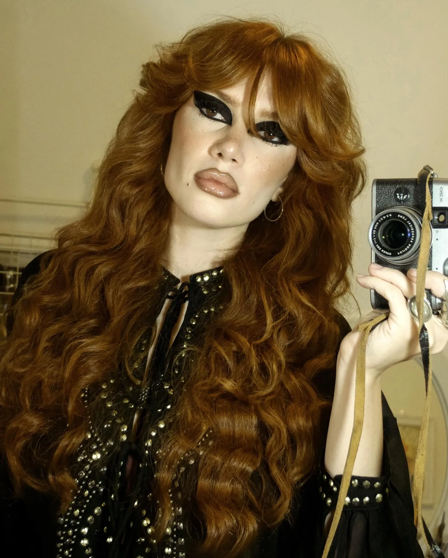 Long voluminous copper curls with curtain bangs