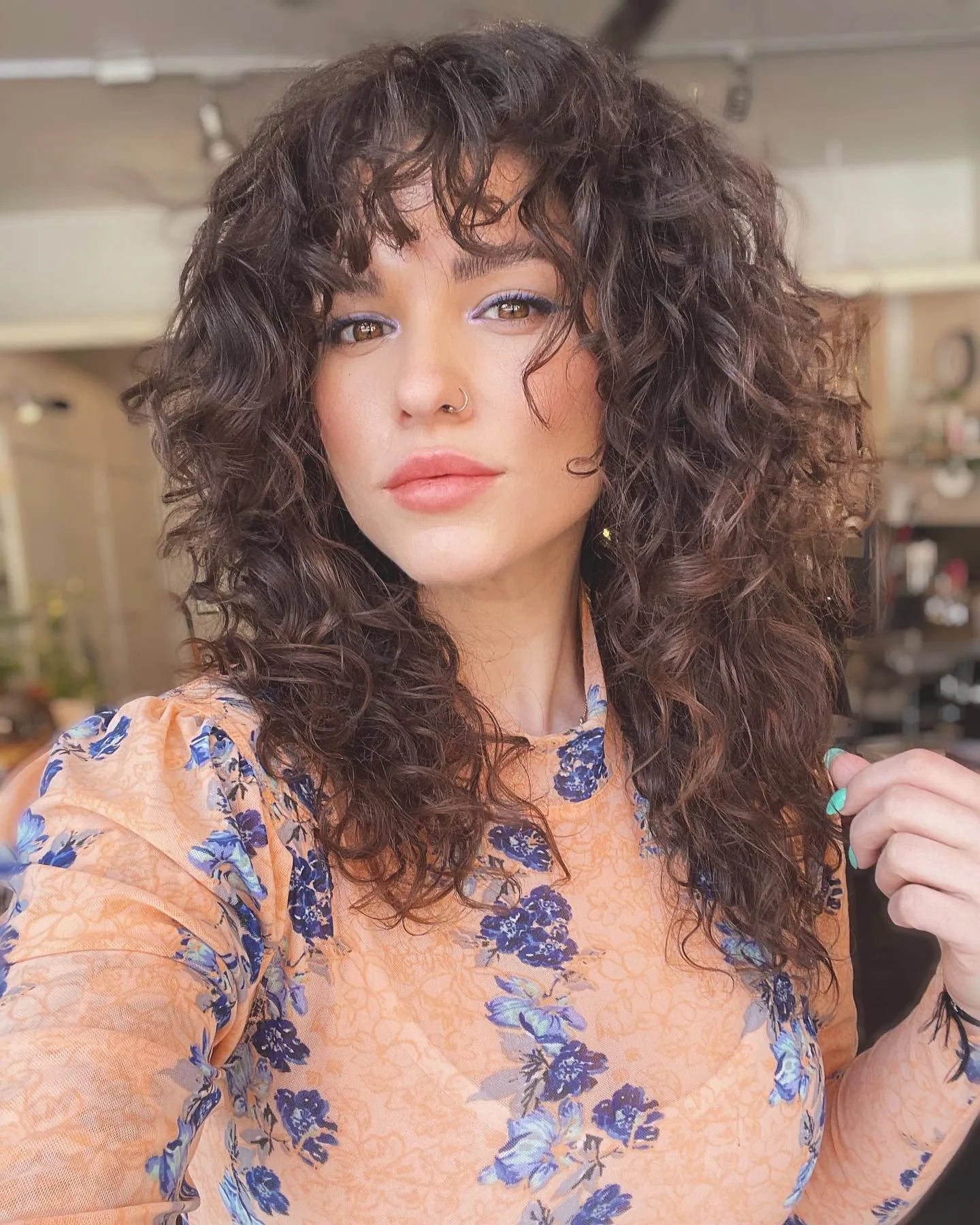 Layered dark curls with bangs and shoulder-length shape