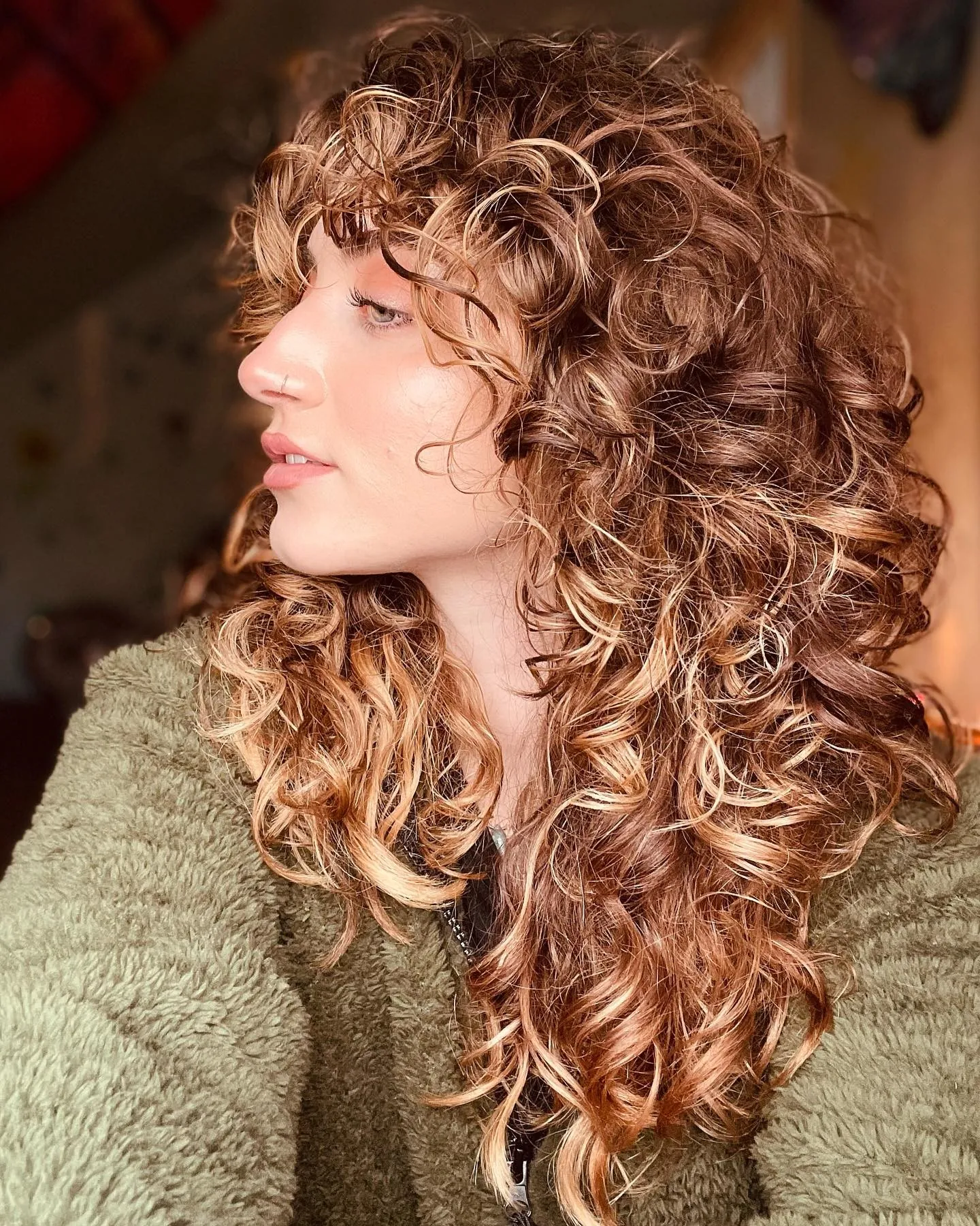 Long copper curls with bangs and cascading layers