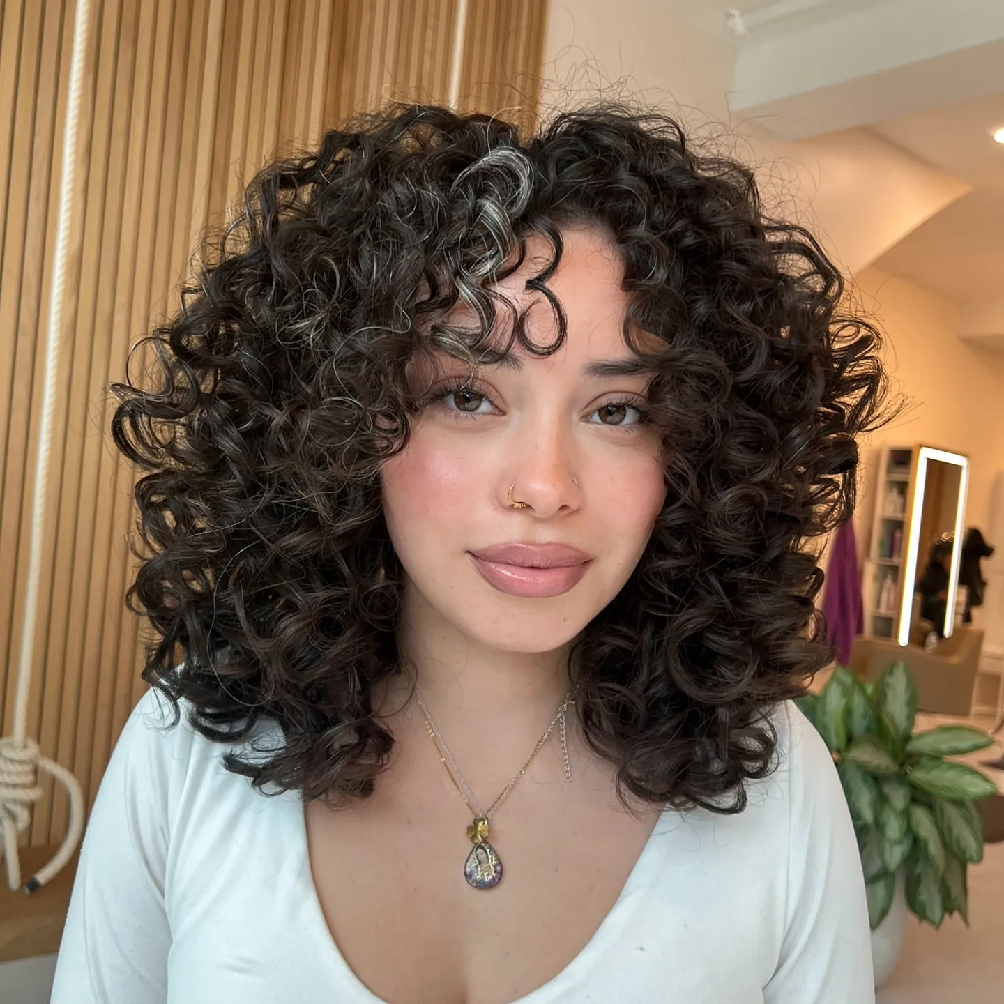 Rounded dark curl layers with face-framing pieces