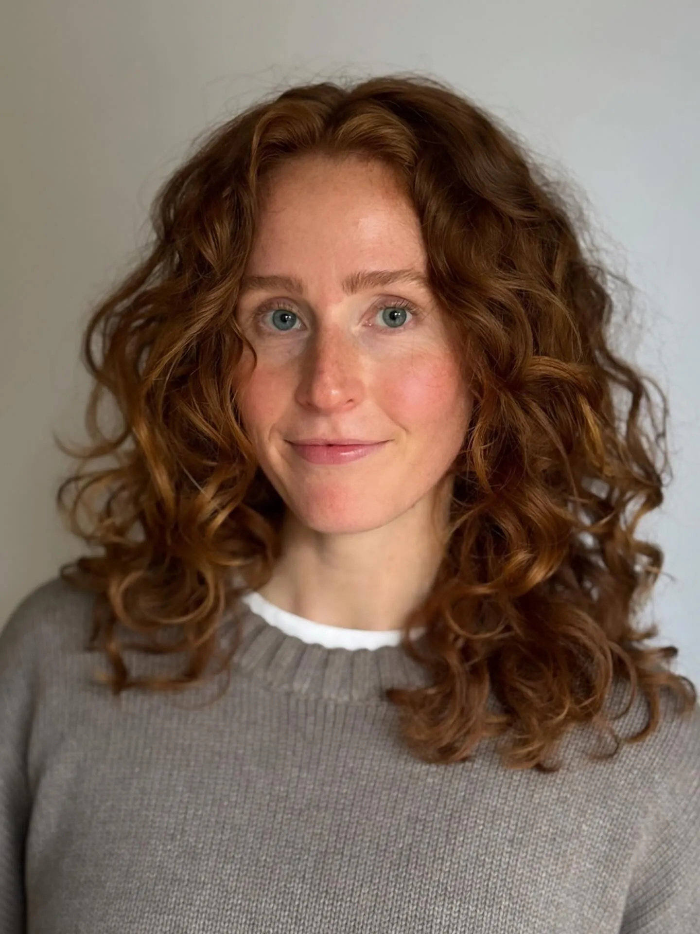Shoulder-length auburn curls with soft layered ends