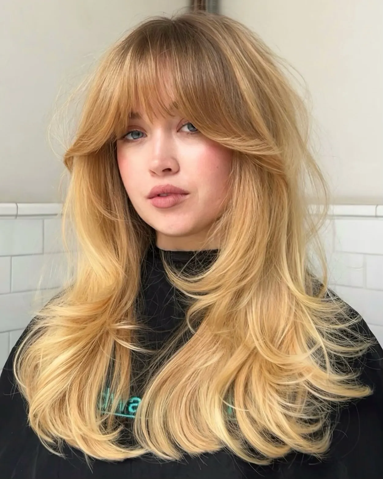 Long blonde feathered layers with curtain bangs