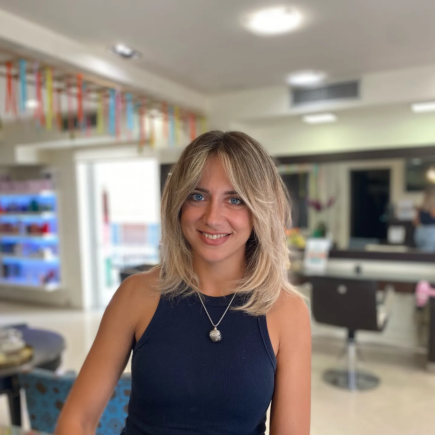 Shoulder-length blonde layers with curtain fringe