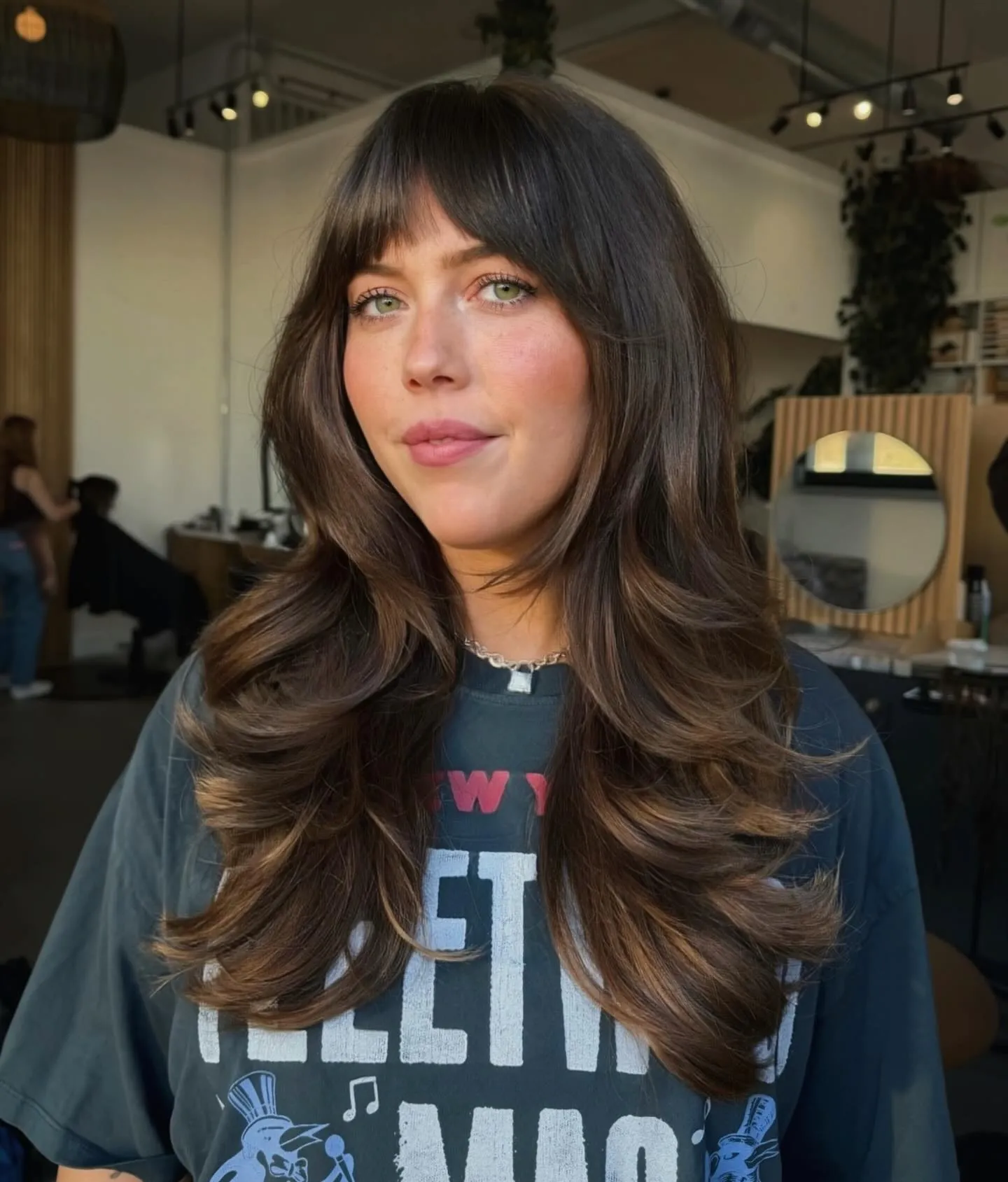 Long dark layers with full bangs and curled ends
