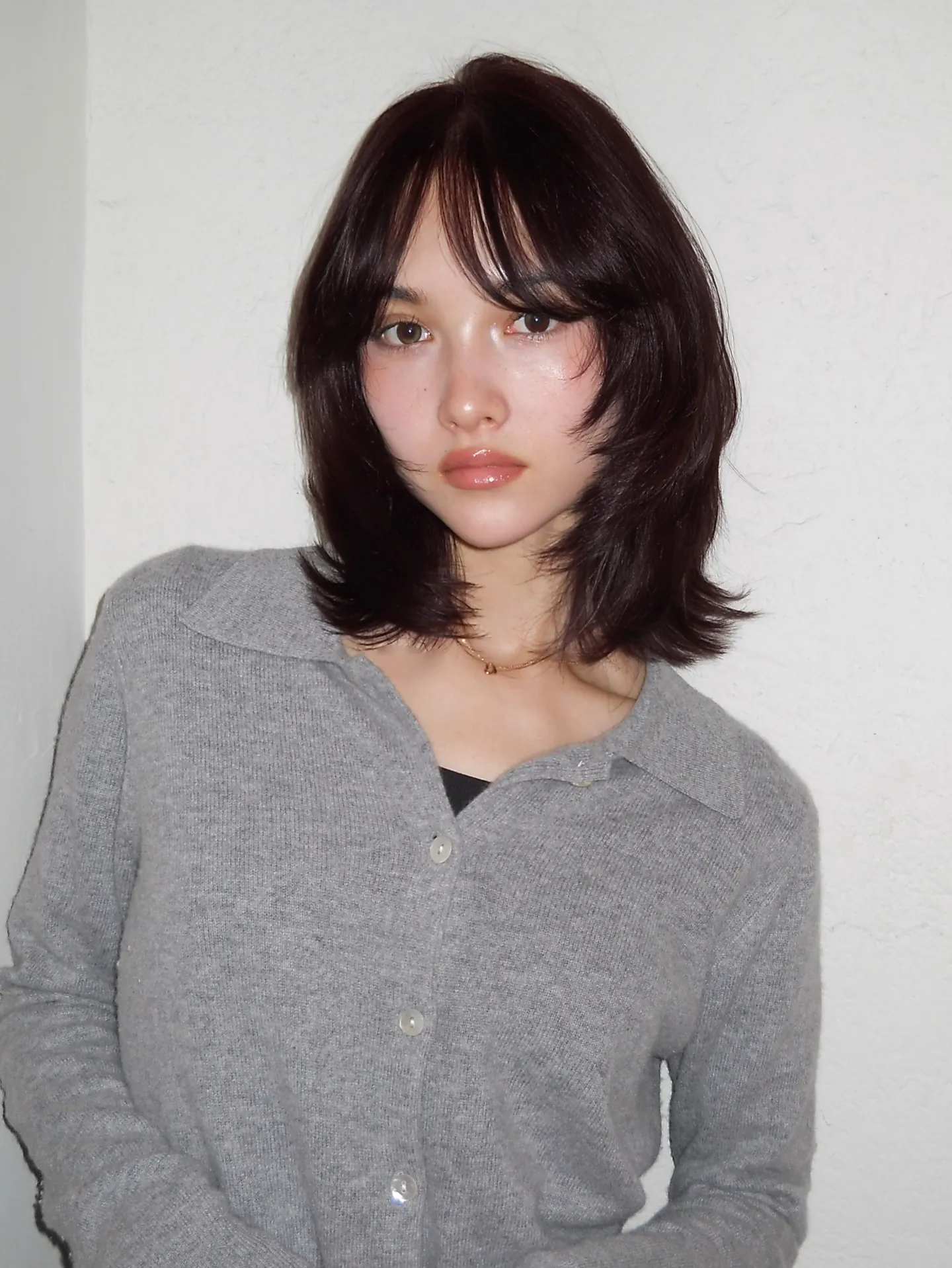 Dark layered long bob with curtain bangs and flipped shoulder-length ends