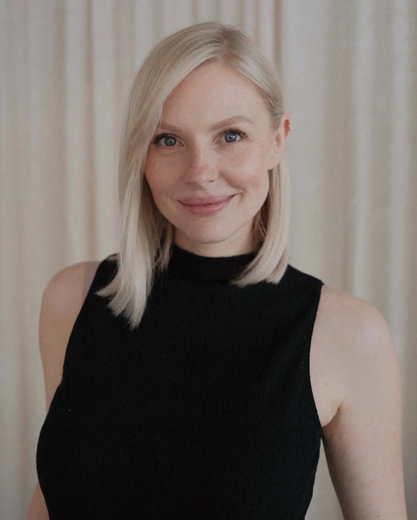 Straight blonde long bob with a side part and one side tucked back