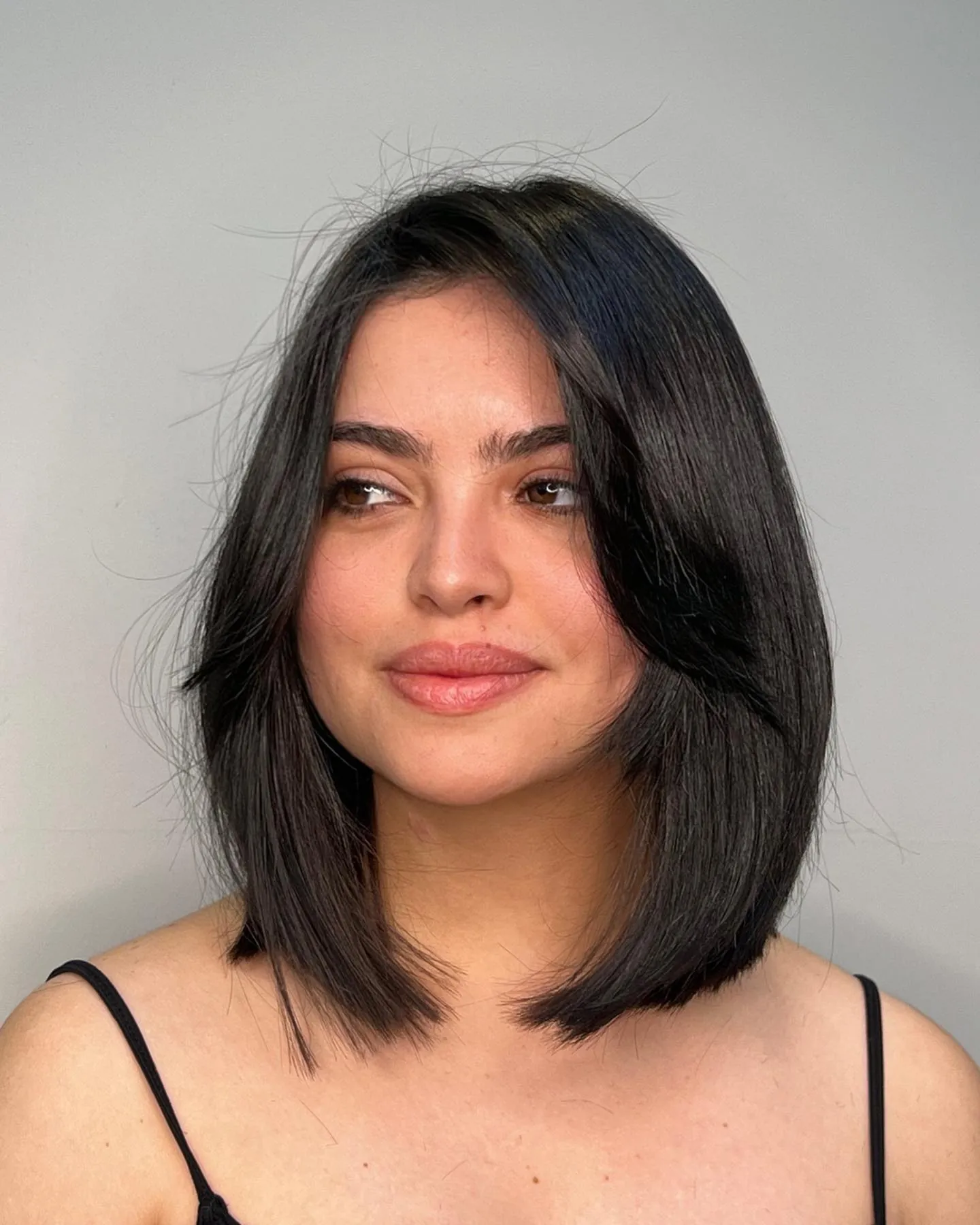 Dark rounded long bob with soft face-framing layers and curved ends