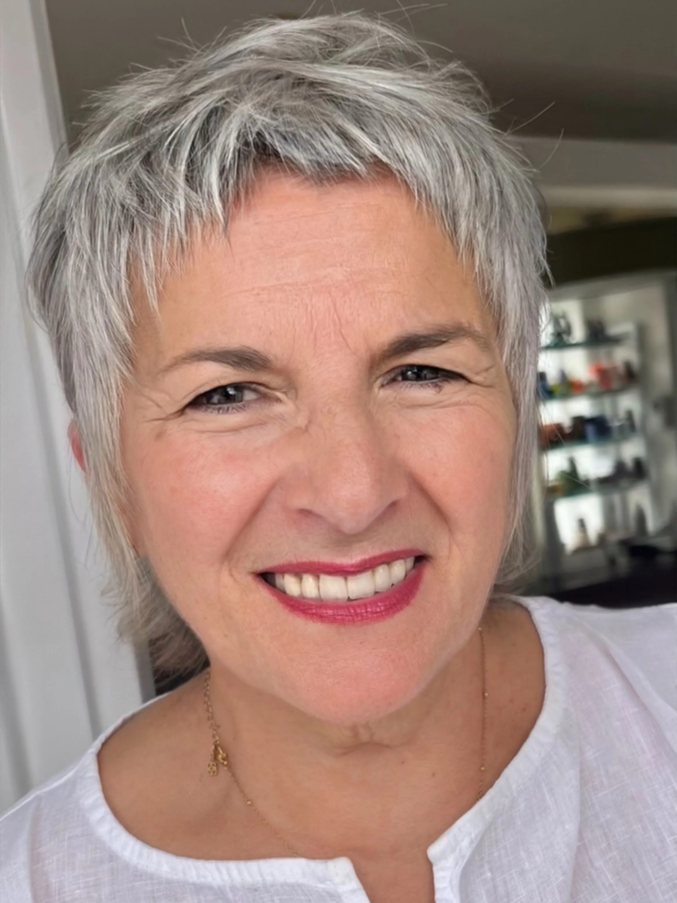 Short silver crop with choppy texture across the crown