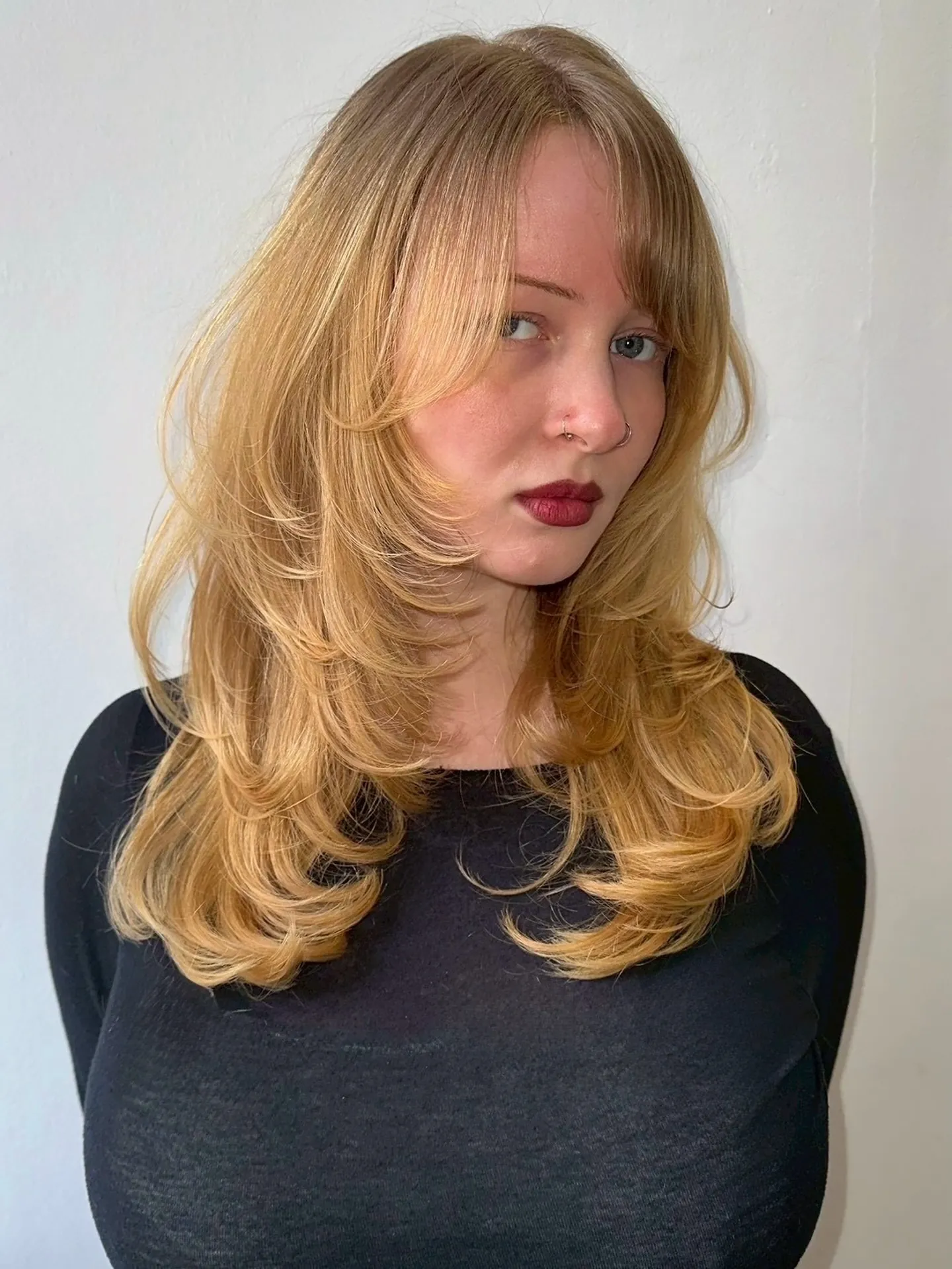 Blonde medium-length hair with voluminous feathered layers