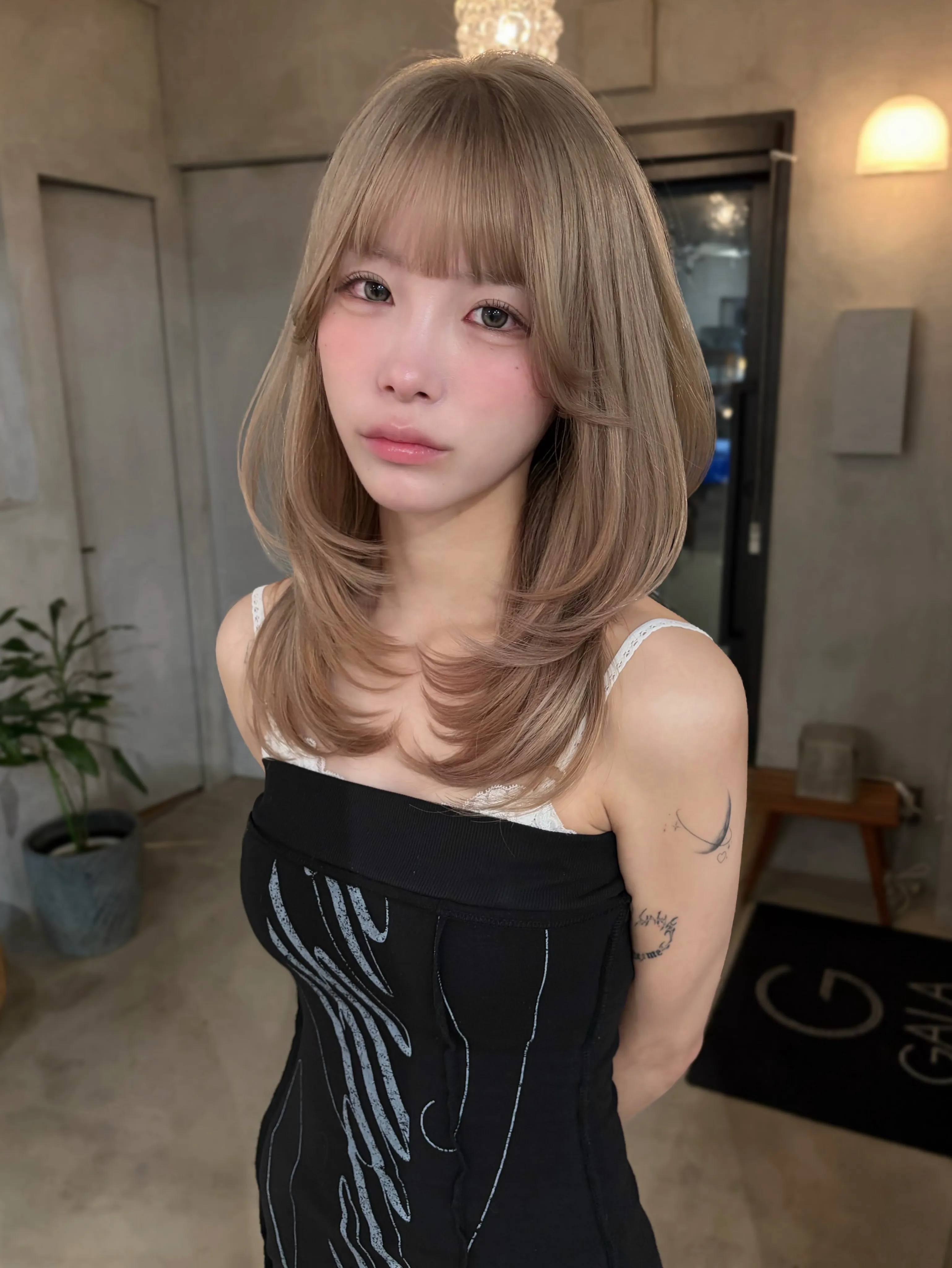 Rounded layered blonde lob with full fringe and curved ends