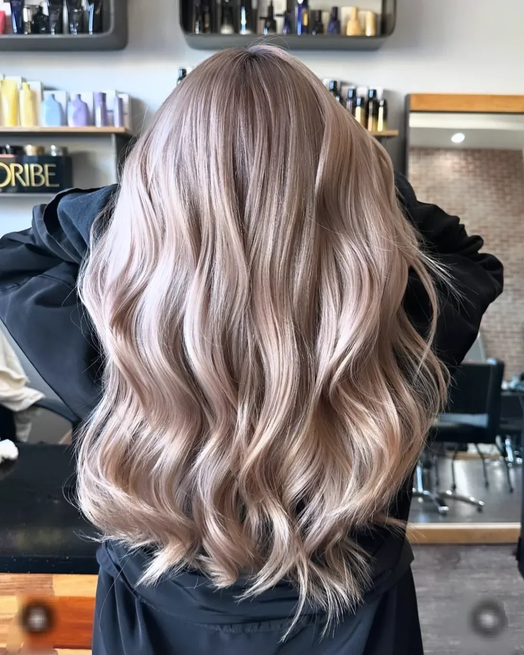 Long milk tea blonde hair styled in loose polished waves