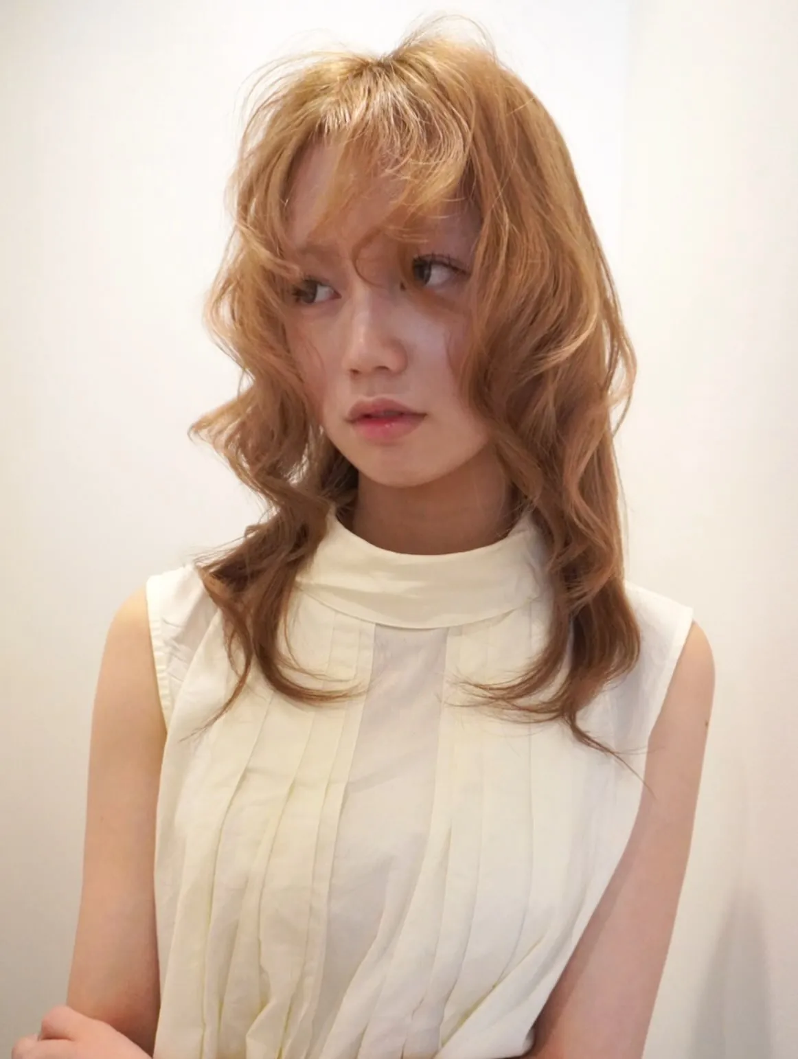 Layered blonde blowout with airy full fringe and curved ends