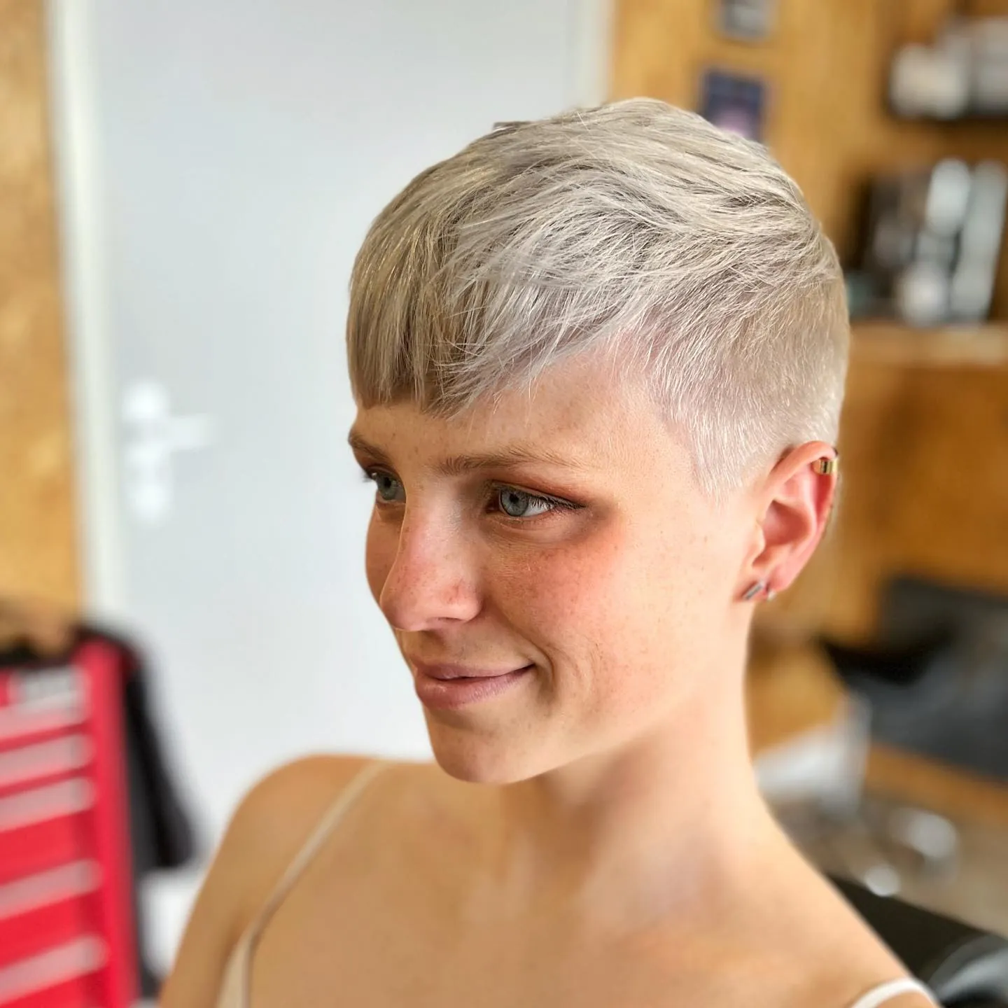 Pale blonde pixie with a side-swept top and closely clipped sides