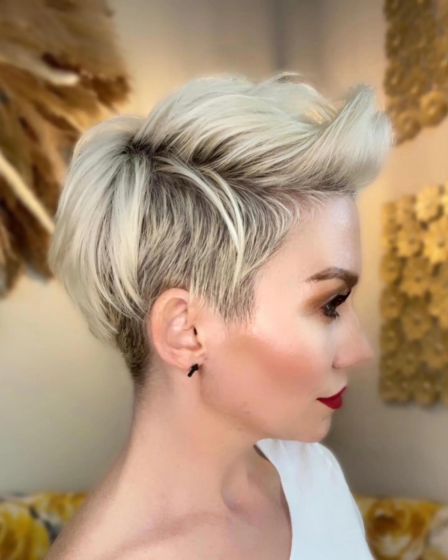 Pale blonde pixie with short sides and a lifted quiff
