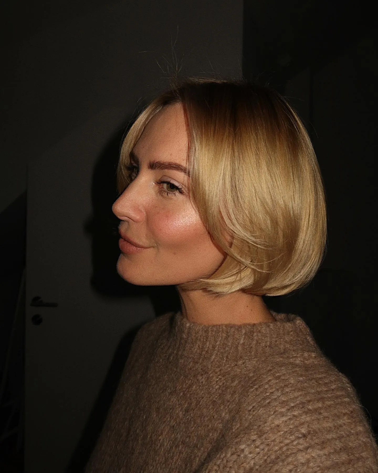 Blonde Prada bob with centre part and tucked ends