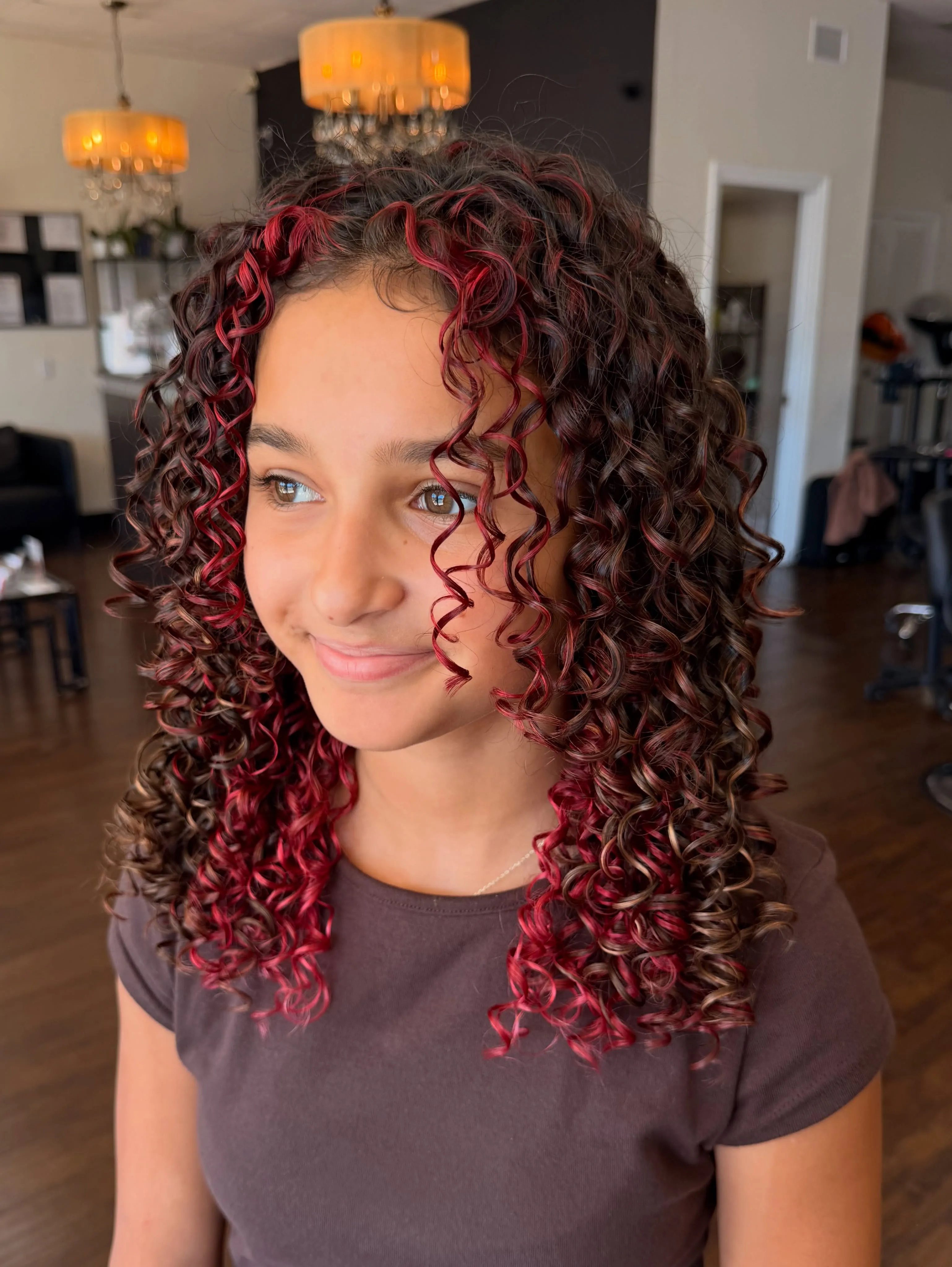 Long defined curls with a center part and red accents