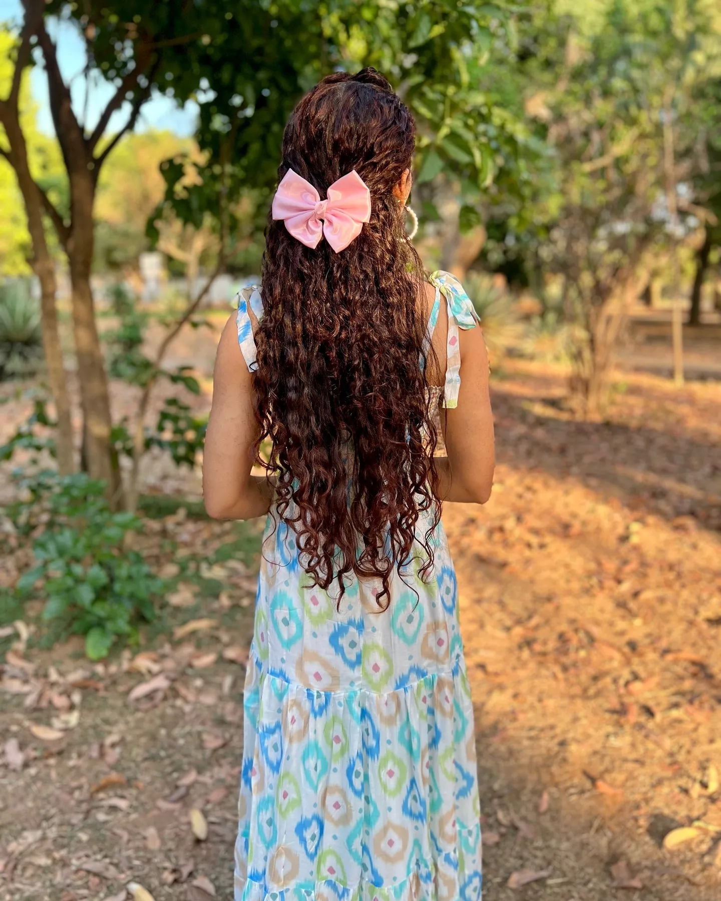 Very long half-up curls finished with a large bow