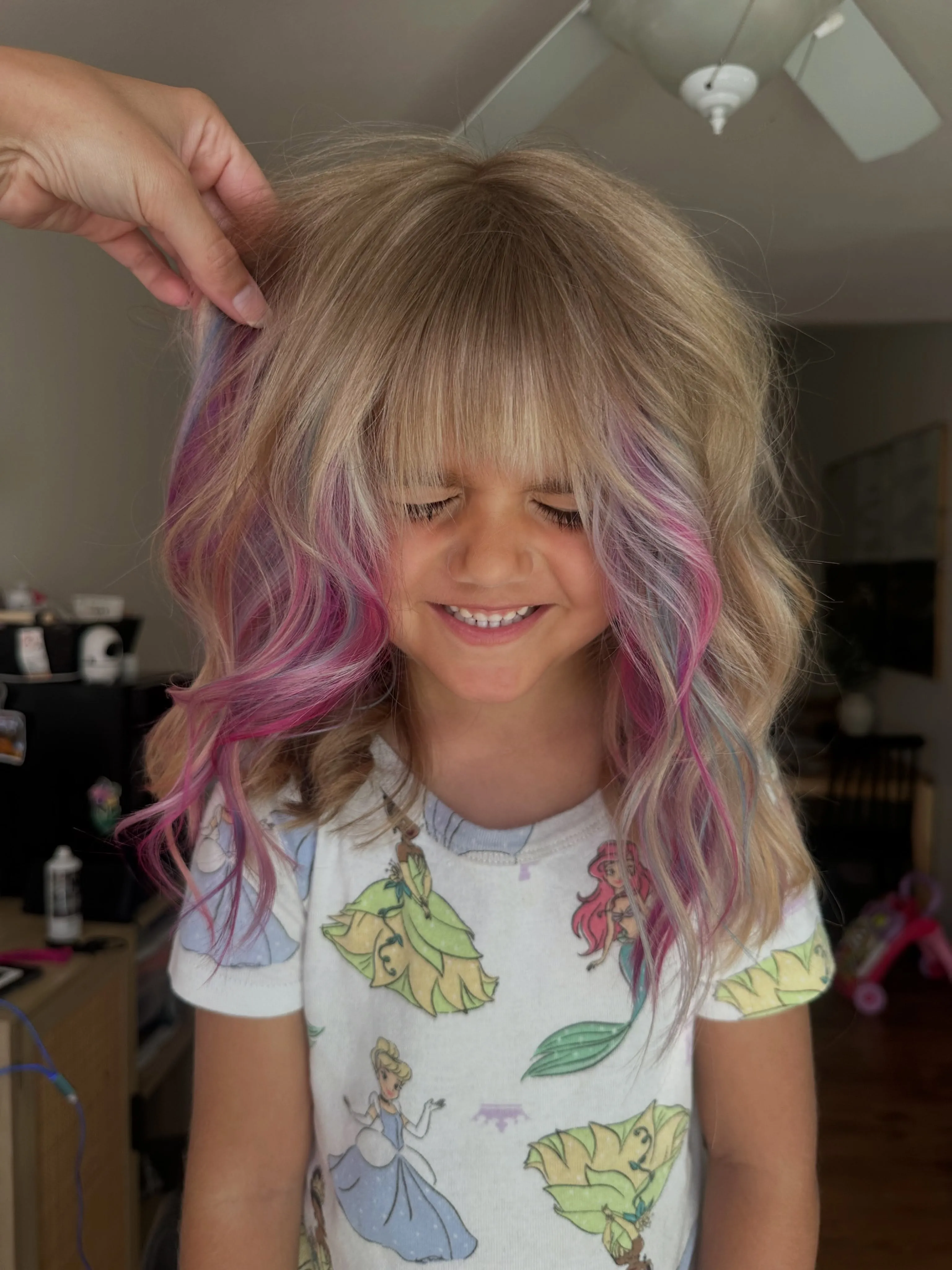 Blonde waves with pink peekaboo colour and full bangs
