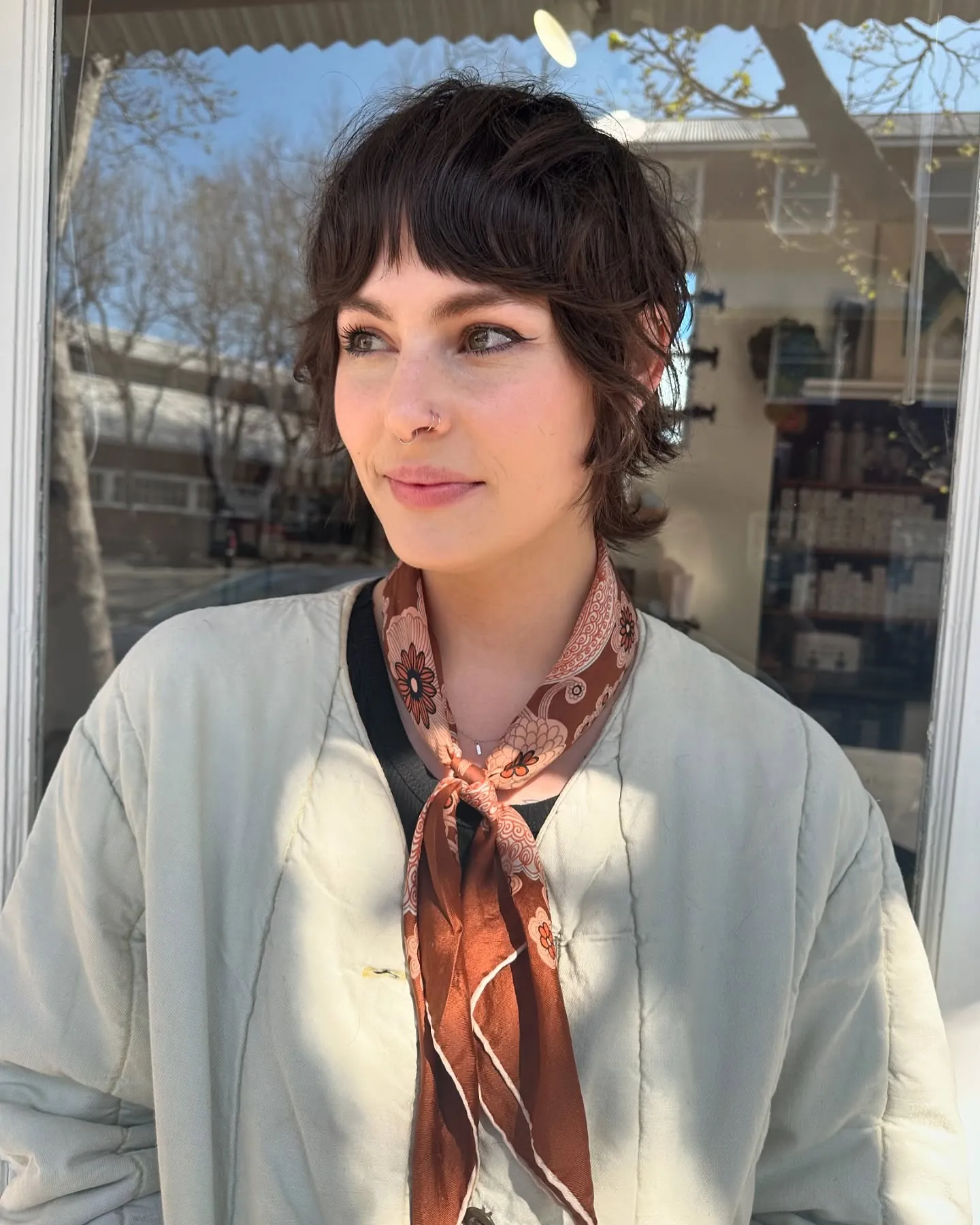 Dark shaggy pixie with curtain bangs and flipped nape