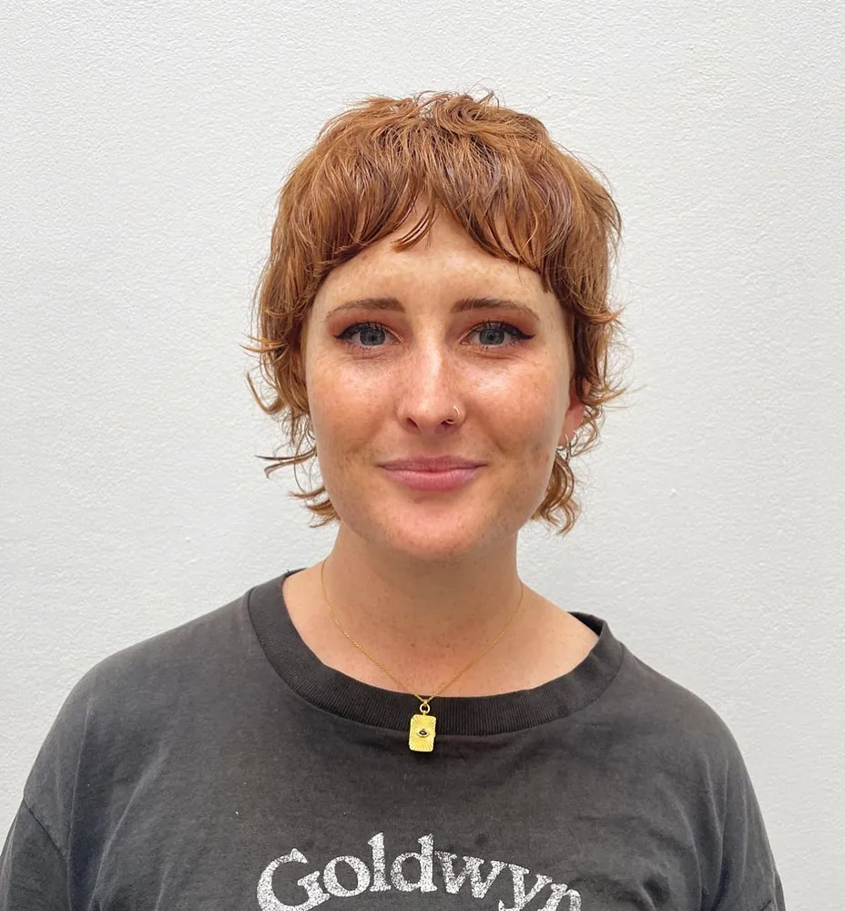 Curly copper shaggy pixie with wispy fringe and longer sides