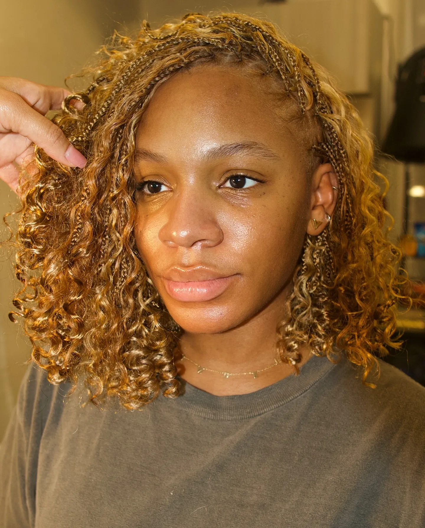 Small braids at the roots blending into shoulder-skimming curls