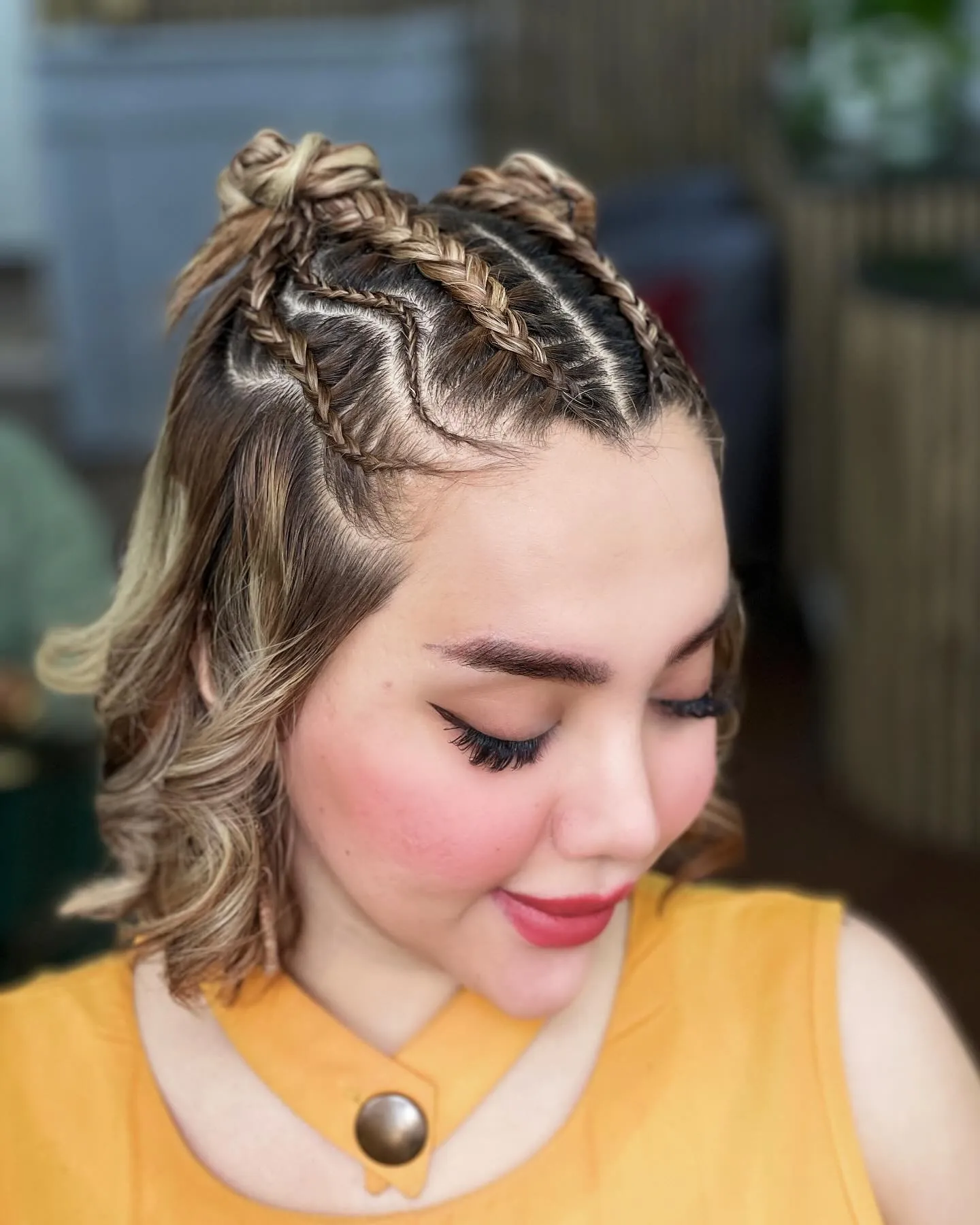 Short wavy hair with two small braided buns on top