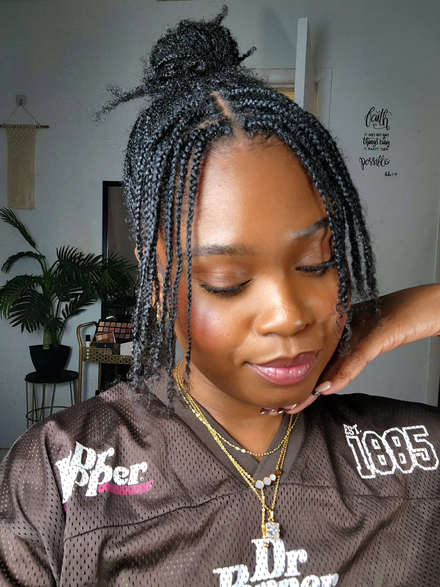 Short braids gathered into a small half-up bun