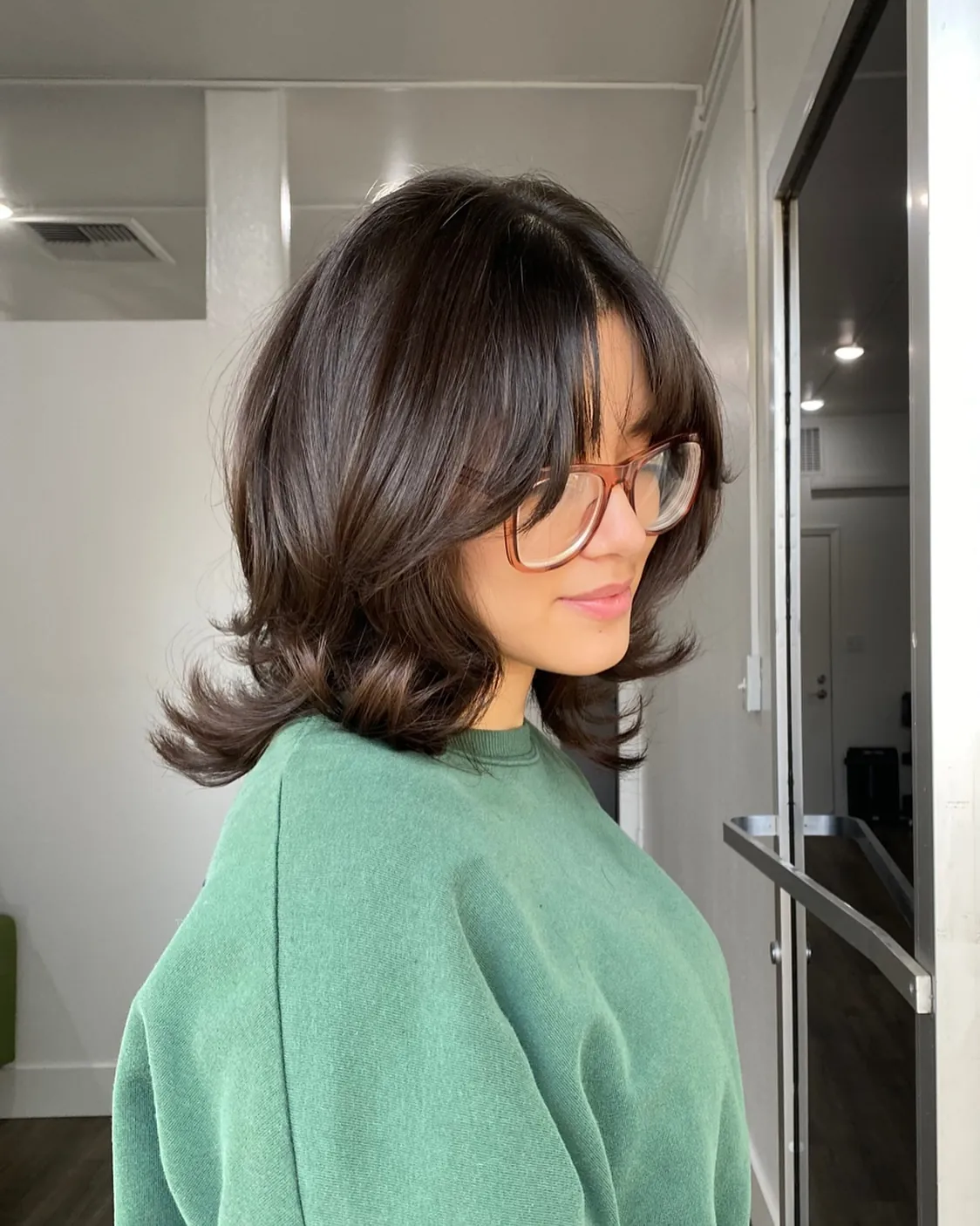 Brunette short layers with curtain bangs and flipped ends