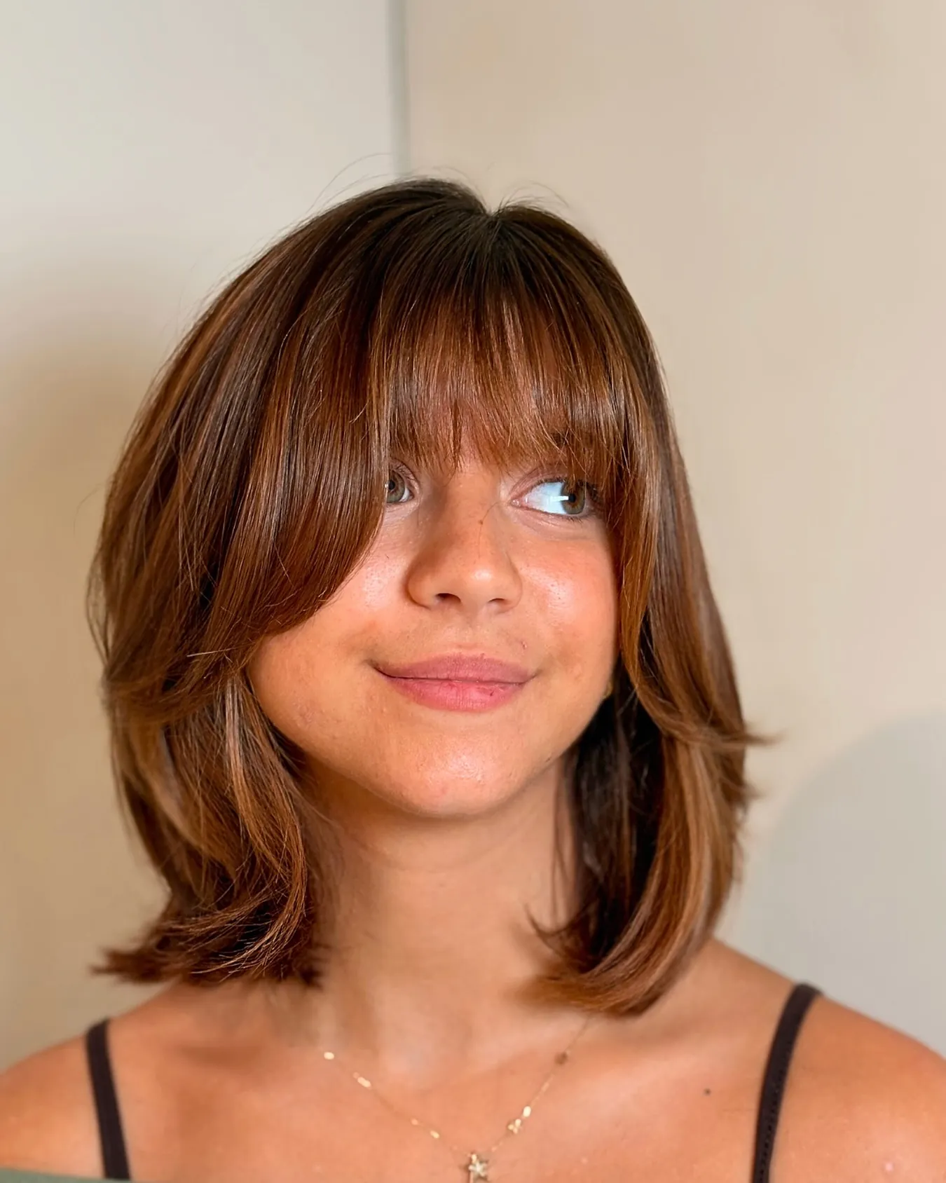 Auburn layered lob with curtain bangs and flipped ends