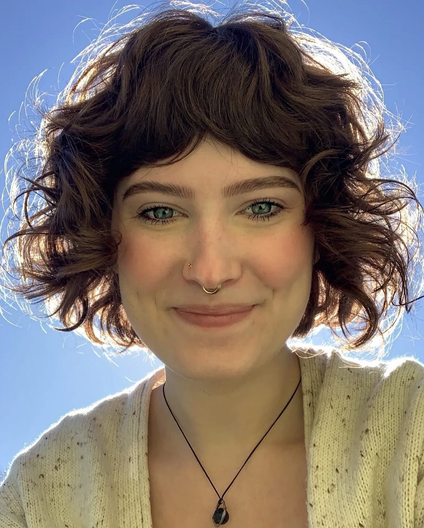 Dark curly shag bob with short rounded fringe